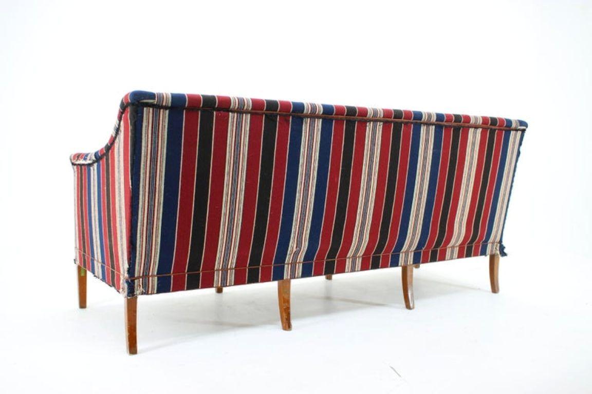 This rare three-seater sofa is a masterpiece of Danish Modern design by the legendary architect Kaare Klint. Produced by the prestigious furniture maker Rud. Rasmussen, this sofa is an exceptional example of Klint's functional and elegant style. Its