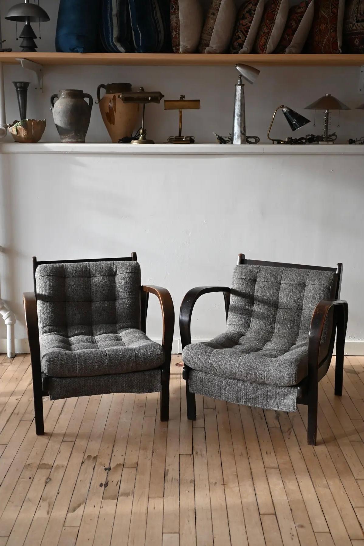 A cool pair of bentwood lounge chairs circa 1940, by mid century icons Koželka & Kropáček. Low slung seats are supported with bentwood that forms the arms and legs. Newly upholstered in Pierre Frays tweeded wool in grey.