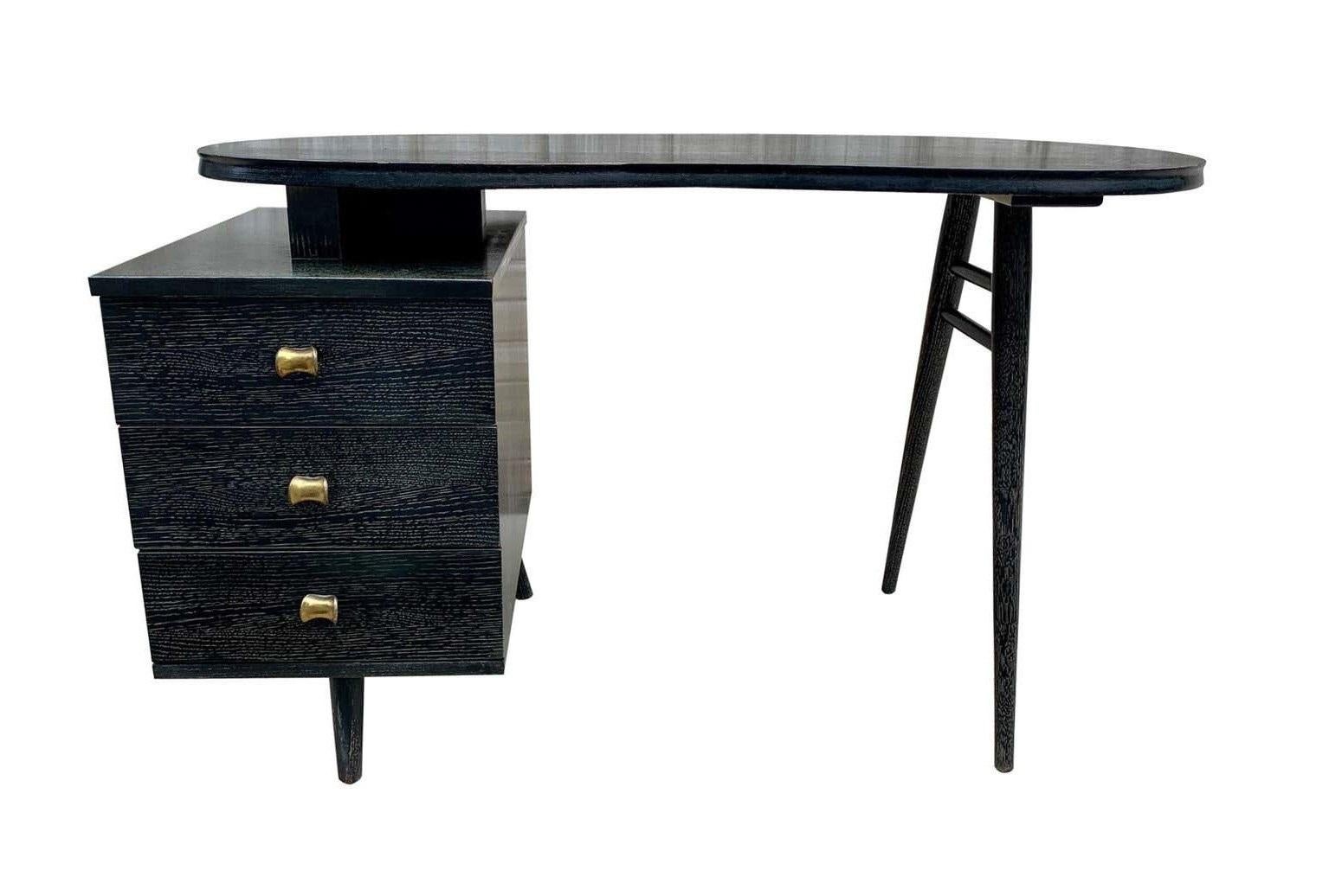 A truly a unique piece! Stunning and extremely rare Art Deco desk designed by Gilbert Rohde, circa 1940. The desk is uniquely designed with architectural lines. The heavy kidney-form top floating above three drawers with brass pulls and turned
