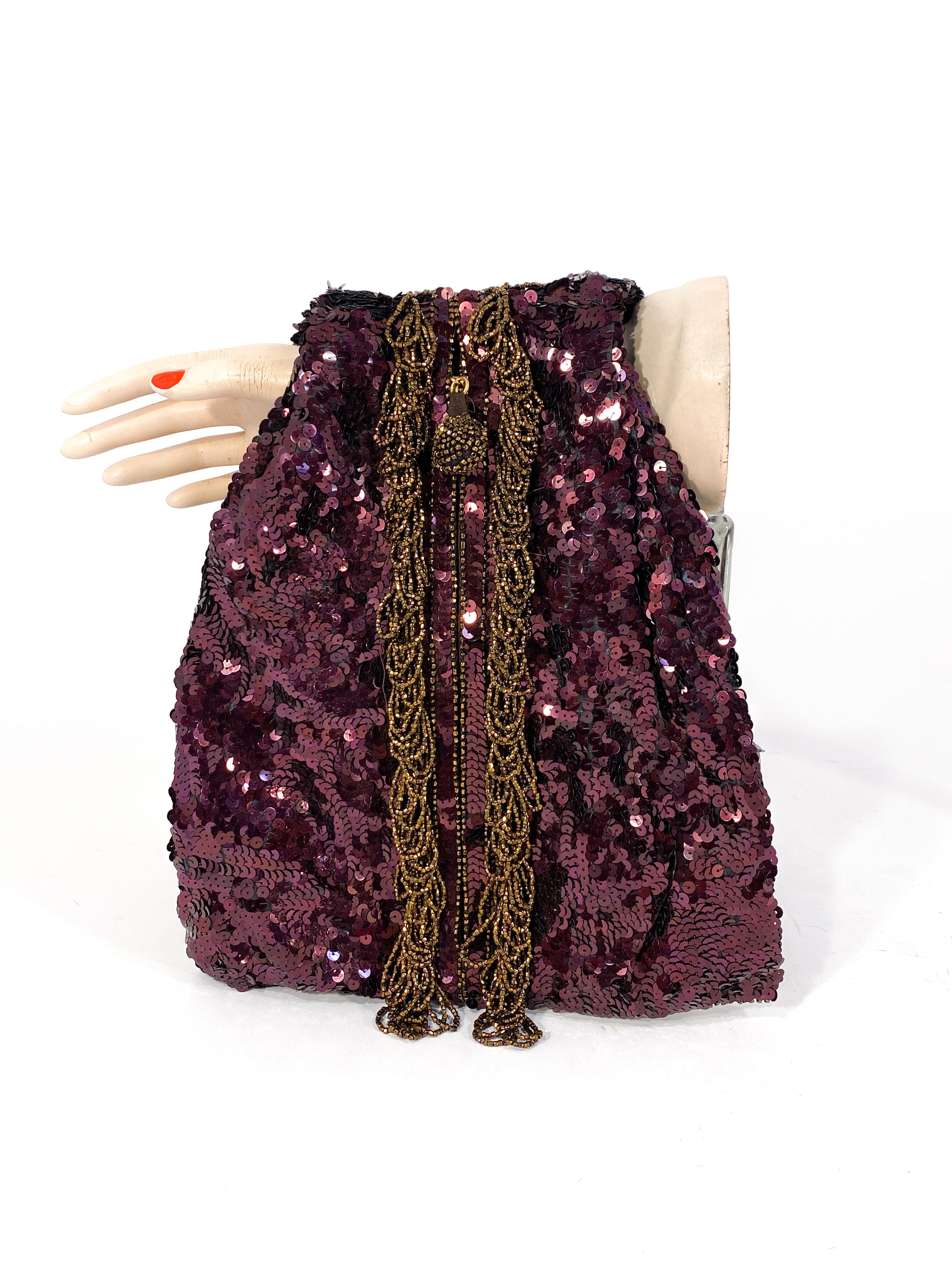 1940s Koret rare maroon handbag sold at Neiman Marcus. The bag is structured two be worn on the arm used for dancing in night clubs. The body of the bag is entirely decorated with brilliant maroon sequin with a strip of copper beaded loops to match