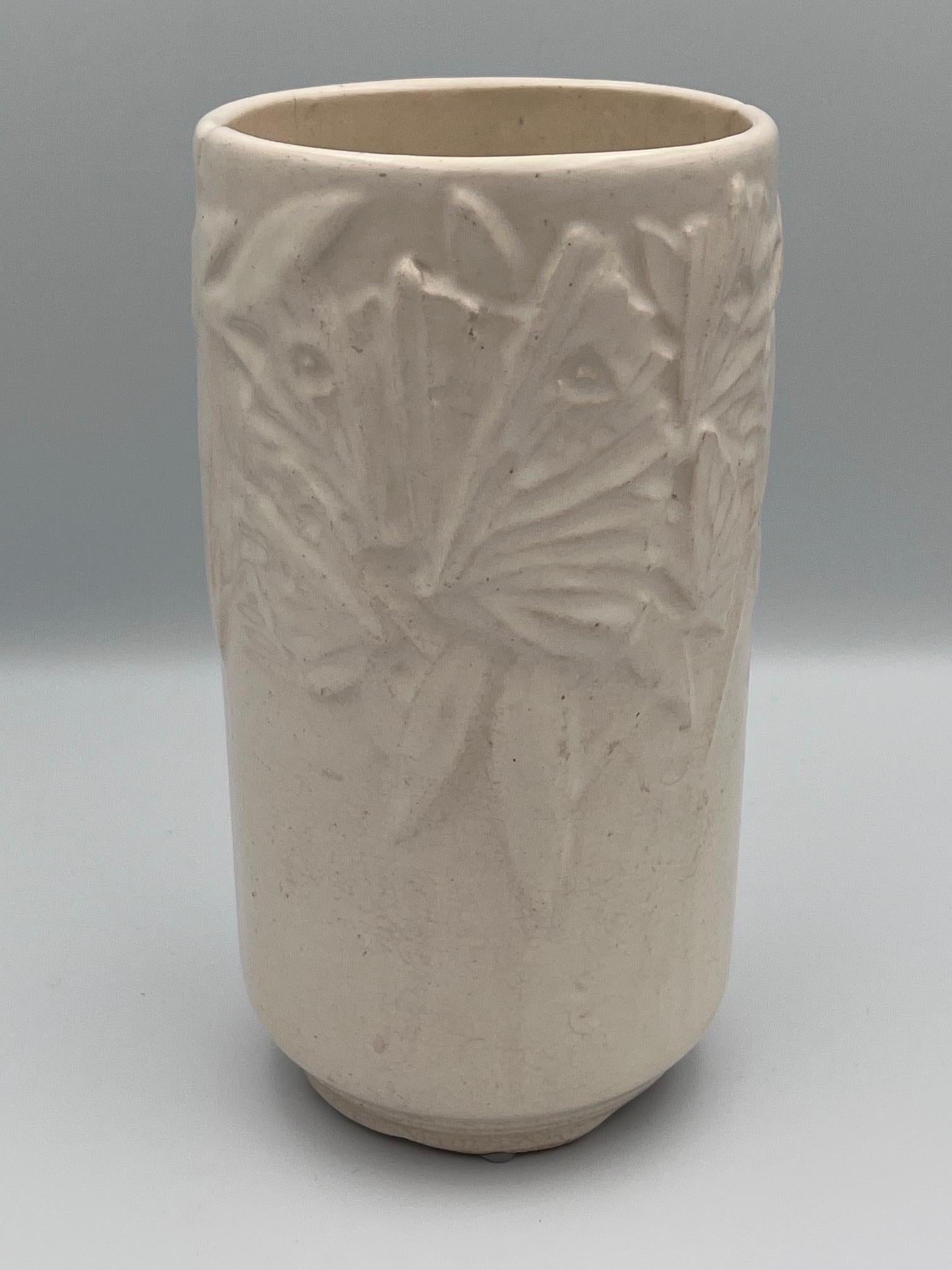 Questo grande vaso cilindrico McCoy Butterfly è un esempio straordinario della maestria dell'azienda, con un bellissimo motivo a rilievo di farfalle che si posano con grazia sulle foglie. Rifinito con un morbido smalto bianco crema, questo pezzo