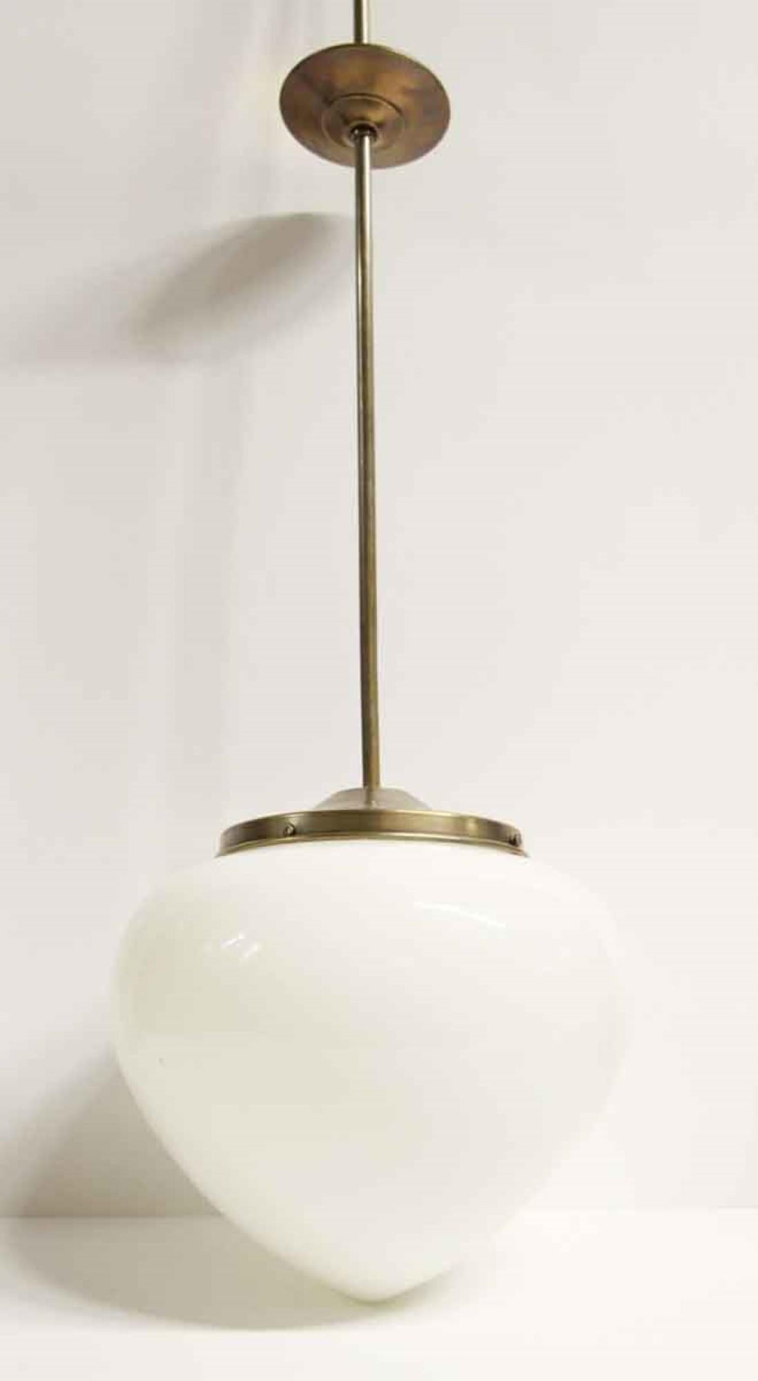 1940s white opaline glass acorn shaped pendant light. Features new antique brass finish hardware. Small quantity available at time of posting. Priced each.