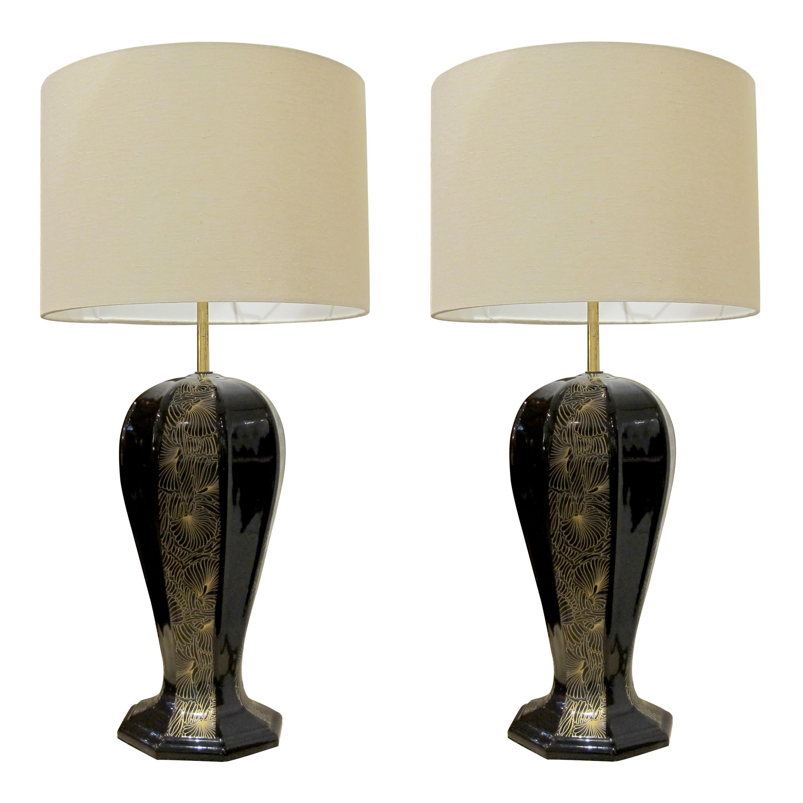 Ein Paar elegante Tischlampen aus den 1940er Jahren mit kühnen, skulpturalen Keramiksockeln, die eine langgestreckte, geschwungene Form haben, die sich zu einer achteckigen Plattform verjüngt. Die glänzend schwarze Oberfläche der Keramik wird durch