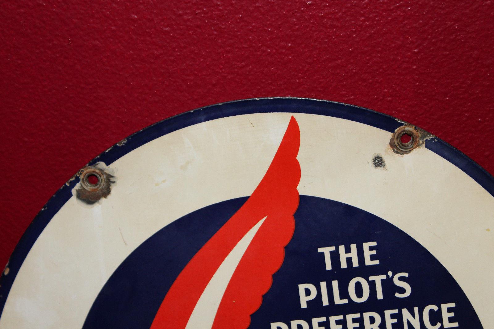 The sign has a large red feather type item in the centre. The text reads “The Pilot’s Preference Learadio Sales and Service.”.