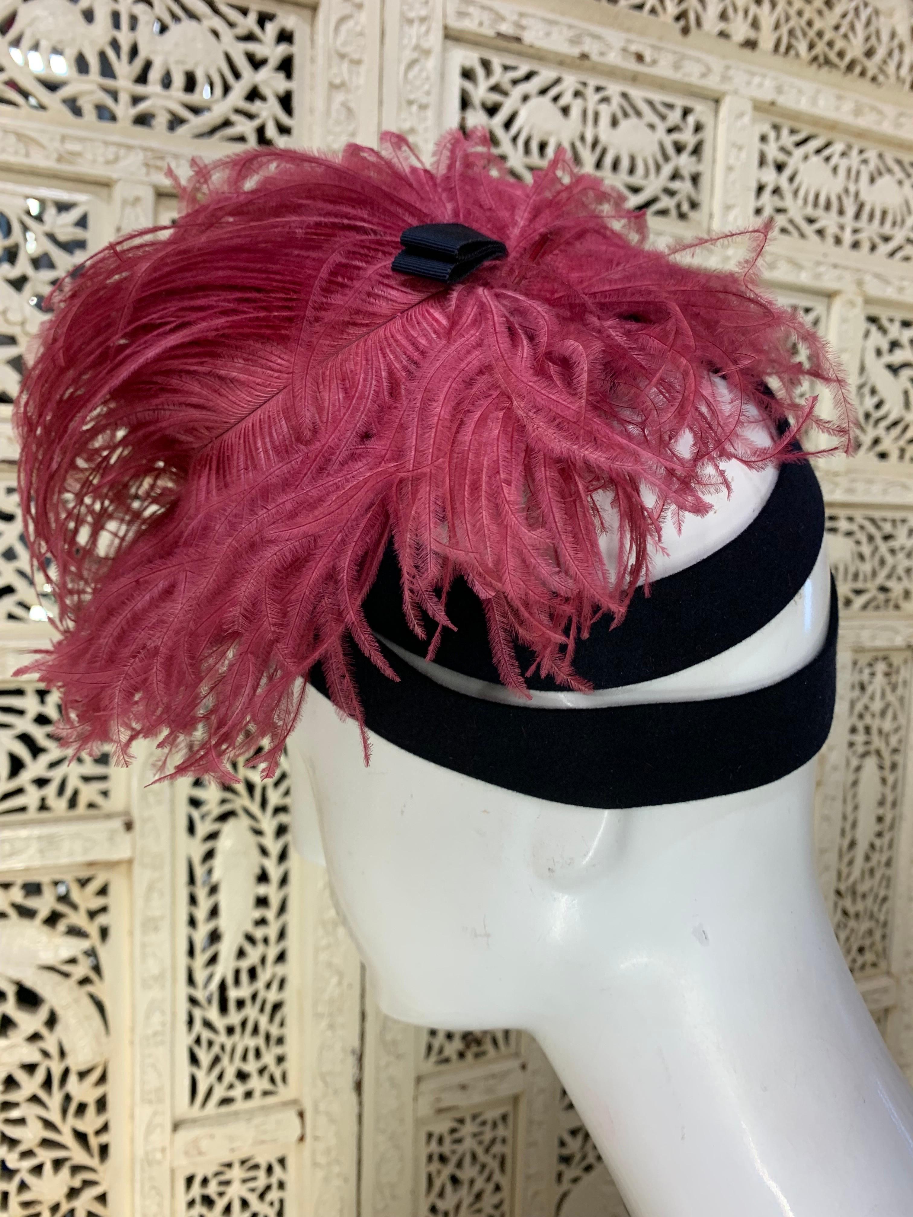 1940s Leslie James Navy Blue Felt Tilt Hat w Large Pink Ostrich Plumes :  Ce chapeau à bascule inhabituel, créé par la célèbre modiste Leslie James, est orné d'une plume d'autruche luxuriante et d'une double bride au dos. Bordure raide sur le