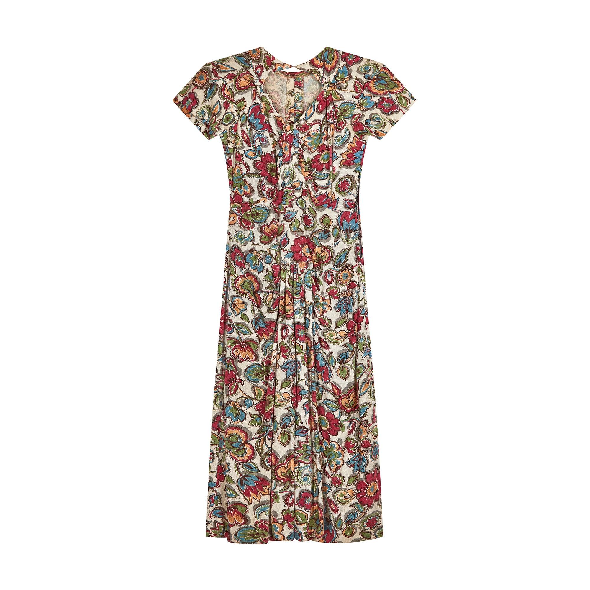 The fabric of this 1940s linen floral dress is resplendent with muted tones of raspberry, ochre, teal and sage florals against a cream background. Tailored to a short-sleeve, tea-dress style with a laid-back drop-waist skirt which is detailed with