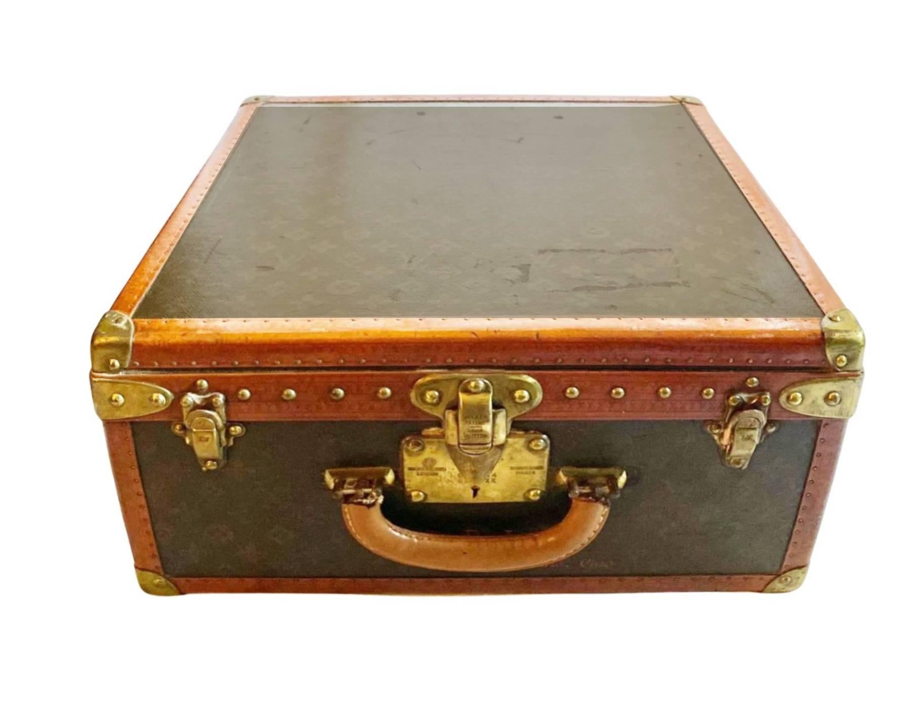 This stunning trunk by Louis Vuitton from Saks & Cy - Fifth Avenue - New York store features brass corners with leather trim, two brass closures and a keyed latch. The handle is brass and the exterior proudly displays the Louis Vuitton original