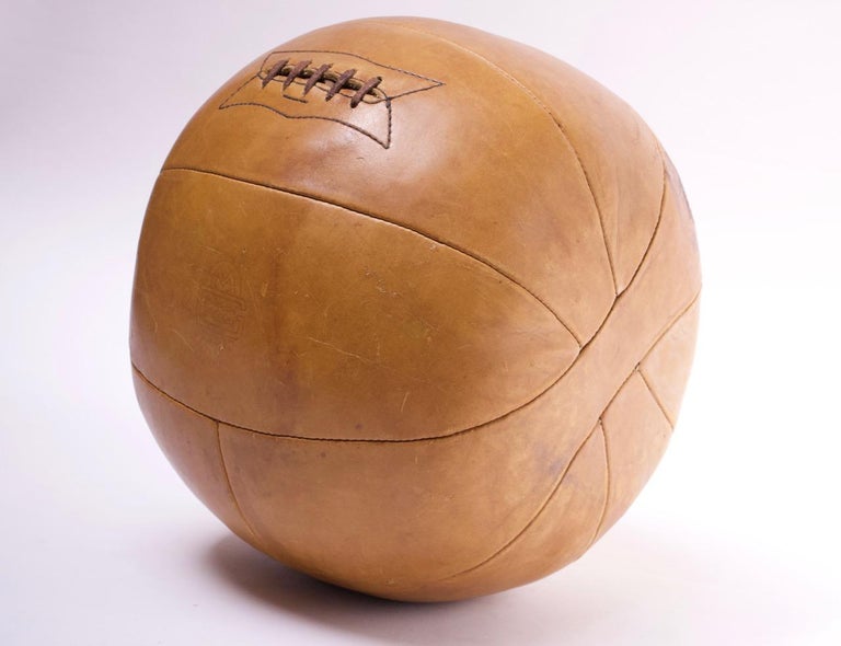 Leather medicine ball weighing 9lbs by MacGregor & Goldsmith, circa 1944-1949. Beautiful patina / signs of natural age in striking caramel-tan leather. Retains the leather lacing.

 