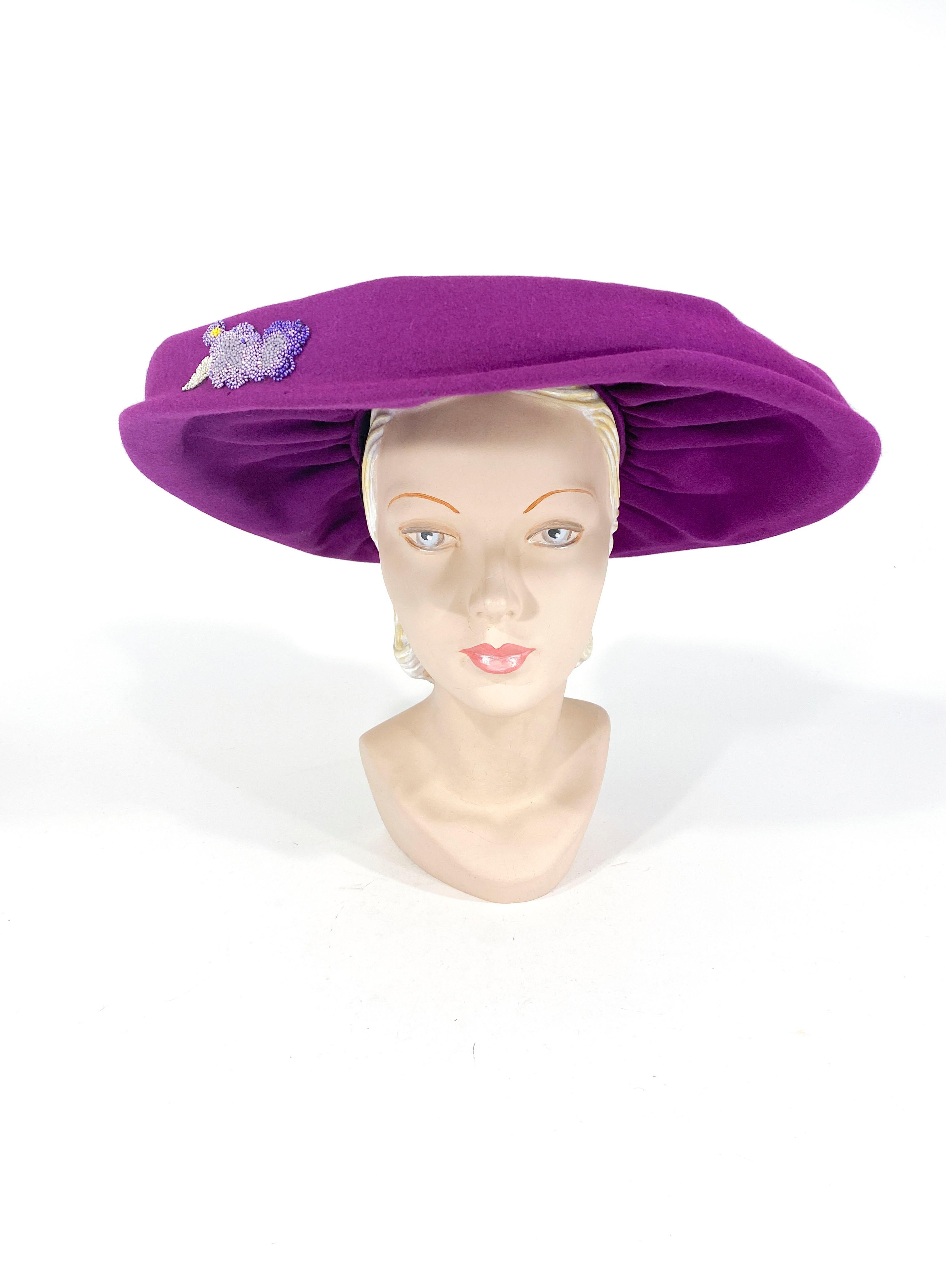 1940s magenta fur felt hat with an open and gathered crown. The wide brim is also gathered and finished with a piping hat band and a hand beaded accent on the side of the front. 