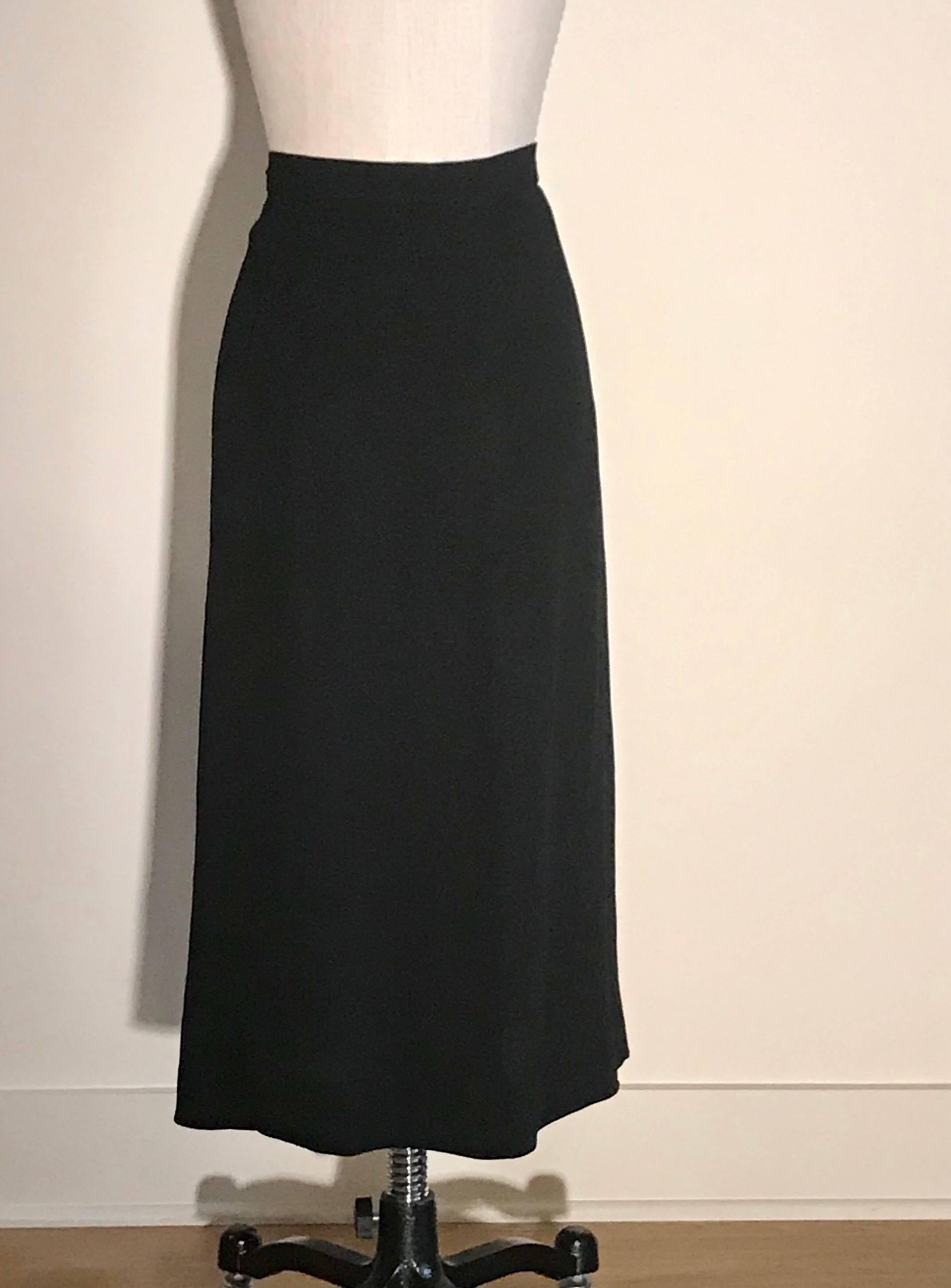 Stunning 1940s Mainbocher Inc black skirt in a lightweight fabric (seems like a light wool crepe) with a plethora of tassels in a chevron pattern at front waist. Side zip with snaps and hook and eyes at waist. 

(Decade is a guess; We initially