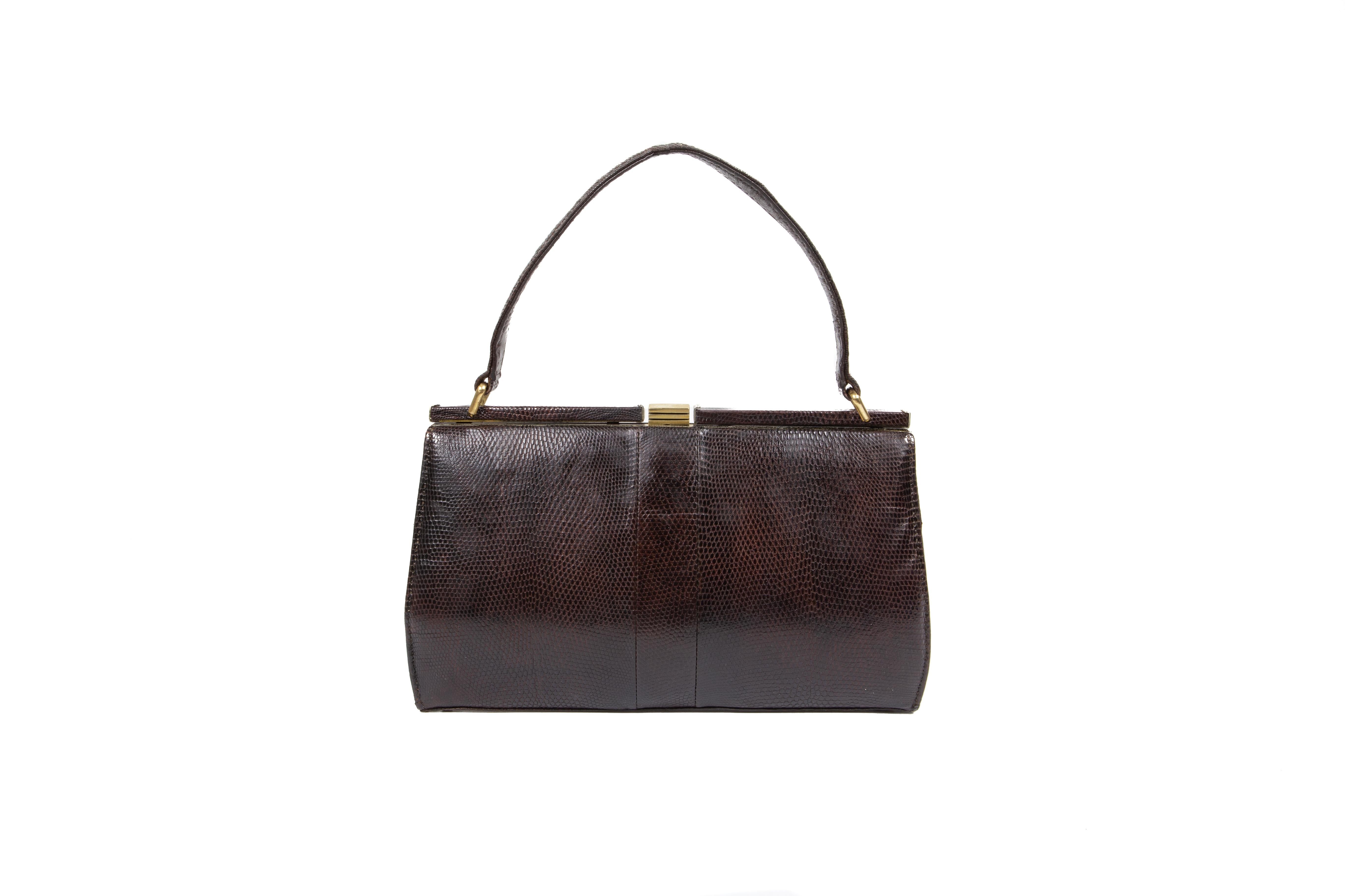 An excellent condition rare late 1940s Mappin & Webb Ltd gently padded dark-bole-brown lizard handbag, comprising of one compartment with one zipper pocket and two patch pockets, fully lined in fulvous-brown suede, mounted on a gilt frame, suspended