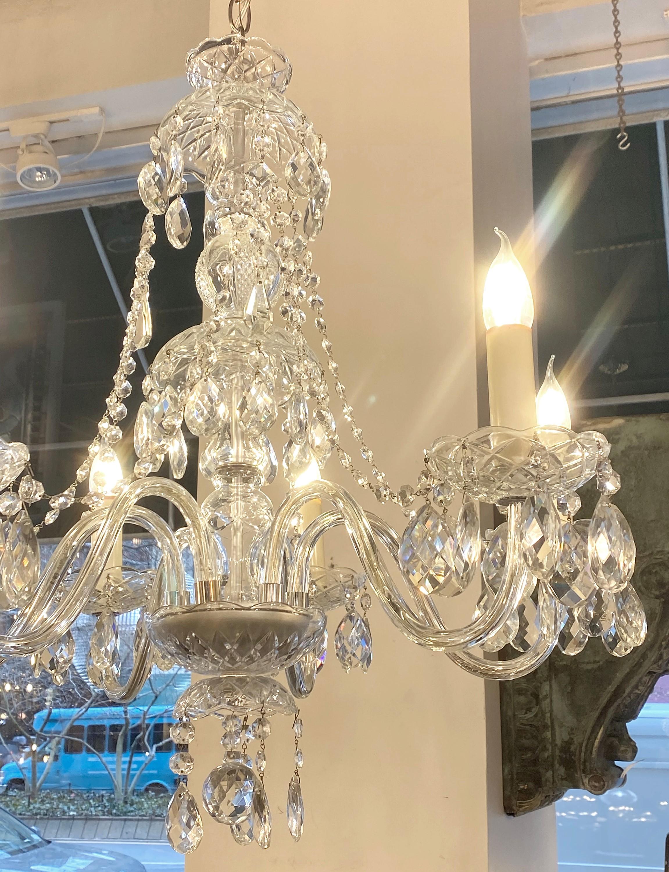 1940s antique crystal chandelier featuring swags of crystals between the arms and almond shaped crystals dripping from the bobeches. Takes six standard candelabra lightbulbs. Cleaned and restored. Please note, this item is located in one of our NYC