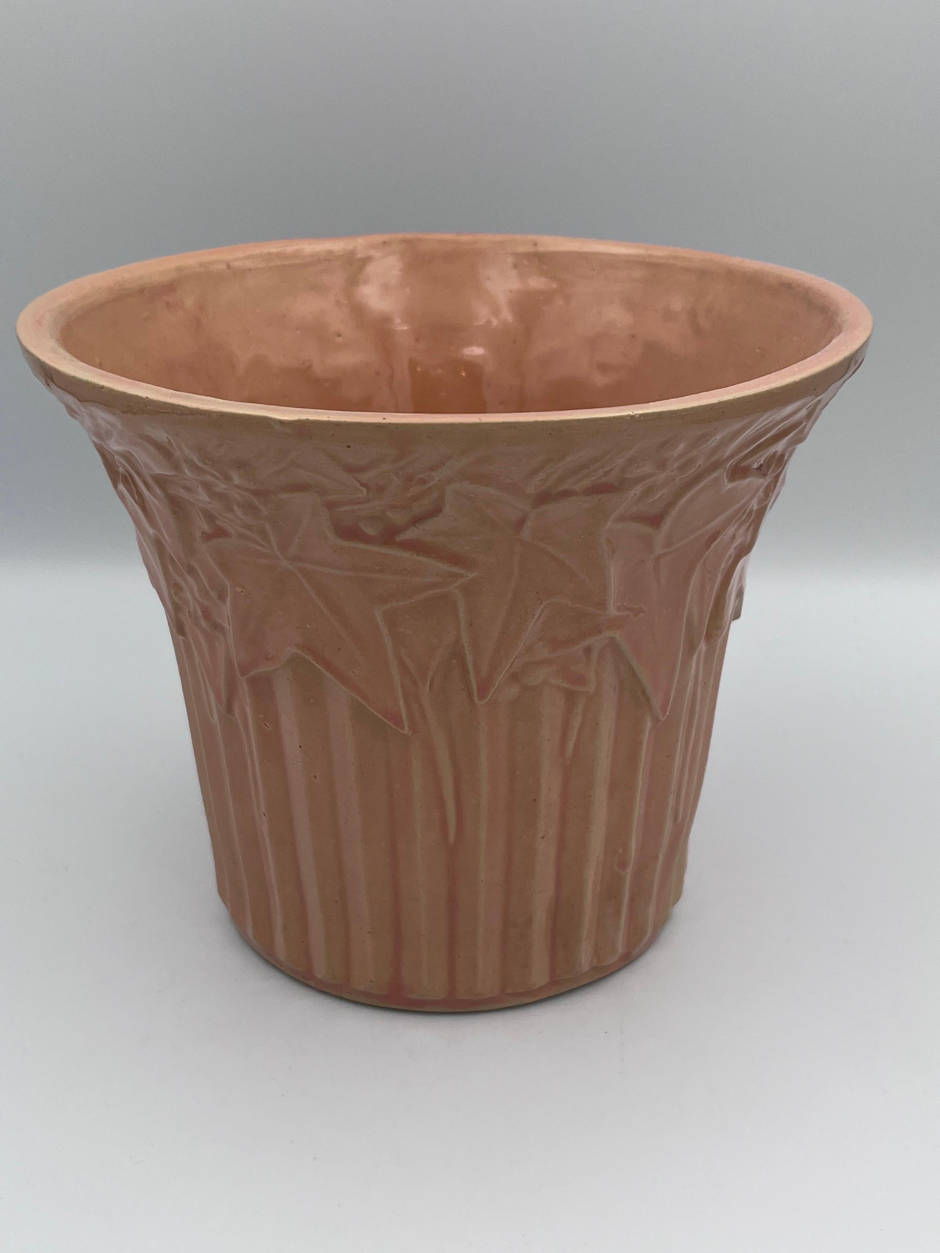 This vintage 1940s McCoy Ivy and Berries planter in a beautiful dusty rose pink glaze is a classic example of mid-century American ceramic design. Featuring a raised ivy and berries motif with crisp detailing and a soft, romantic hue, this planter