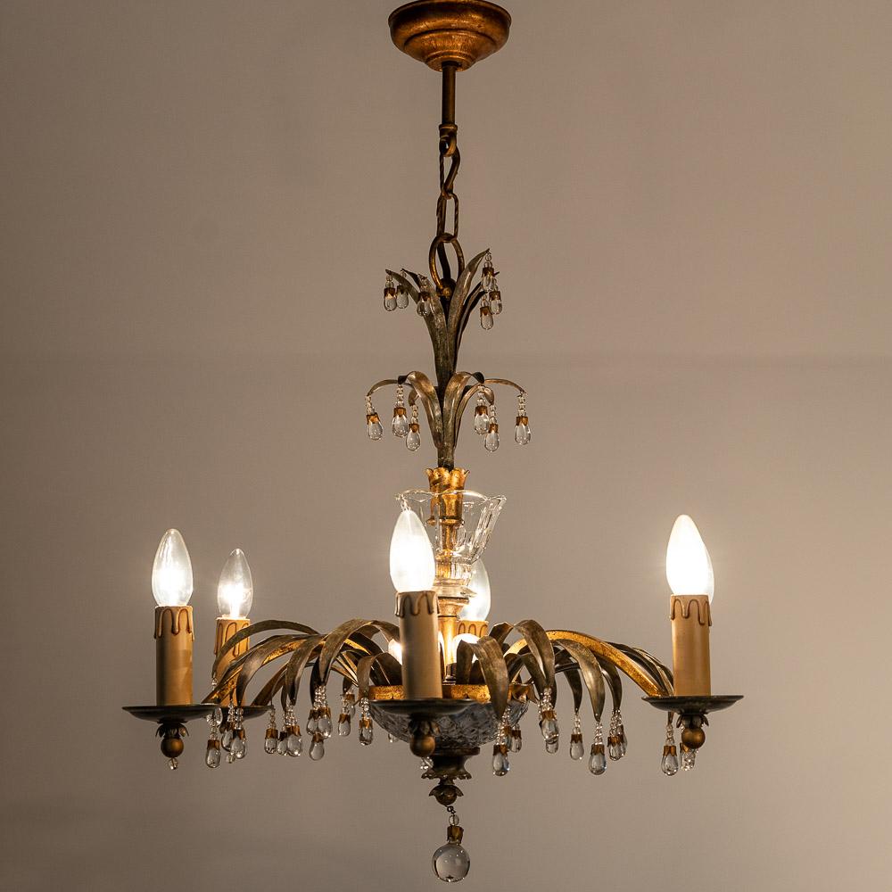This is a stunningly classic decorative Chandelier from 1940s. This lamp has a rich, deep bronze colour while the highly crafted metalwork arms flow elegantly from the solid base. Well crafted glass ornaments.