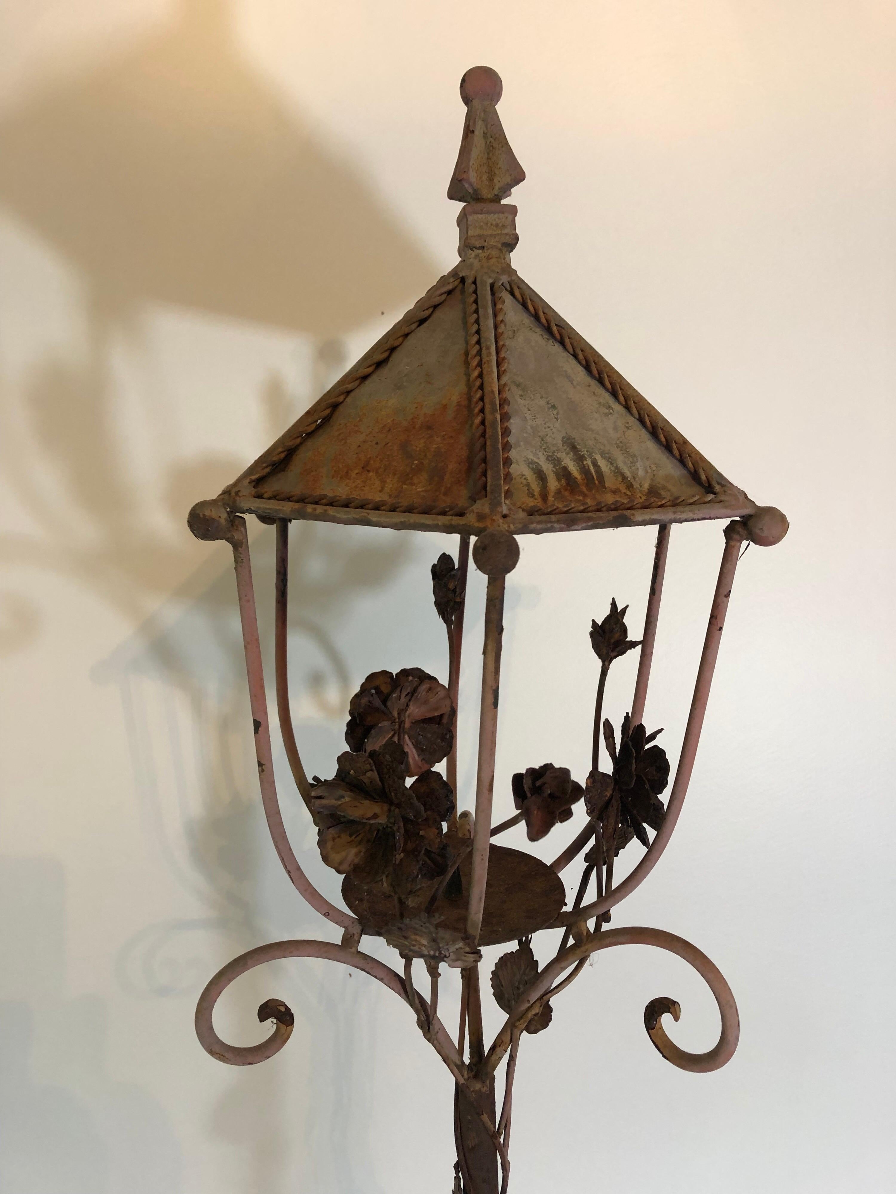 A vintage 1940s metal lantern with single candle pricket. Decorated flower motif with original patina.