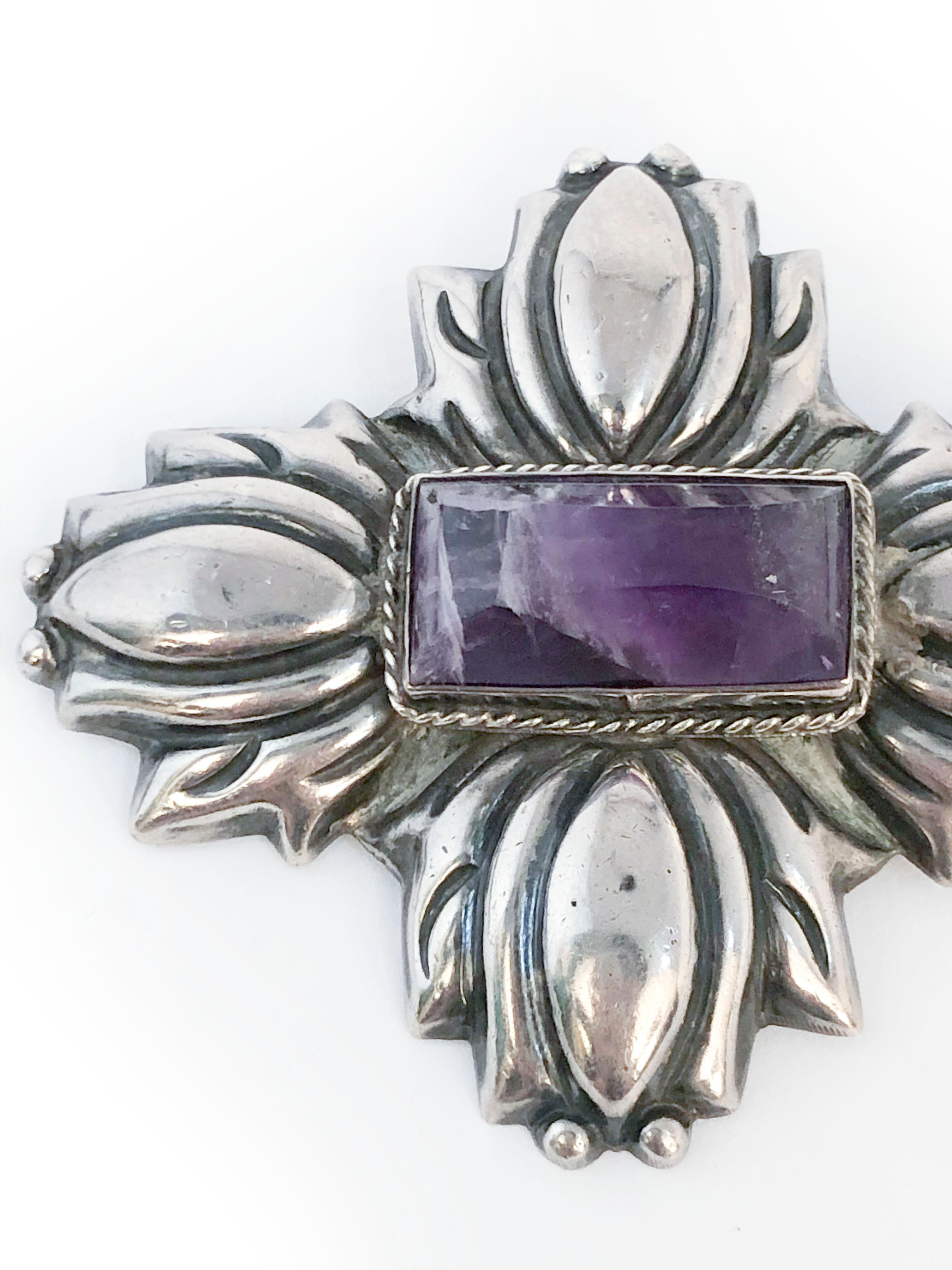 1940s Mexican silver brooch centered with a large marbled amethyst stone. The sliver is hand shaped into a floral tulip-like shape and a large long pin along the back of the brooch. 