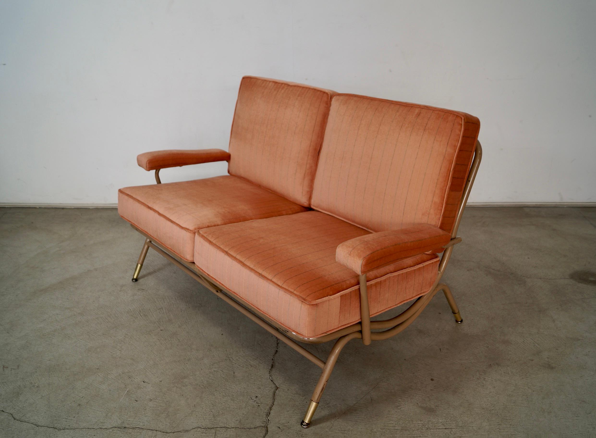 Vintage original Midcentury Modern couch settee for sale. Manufactured by the special Lloyd Manufacturing Company. It has a metal frame with frames on the seat, and solid brass caps on the legs. We had new cushions made with vintage pink velvet. The