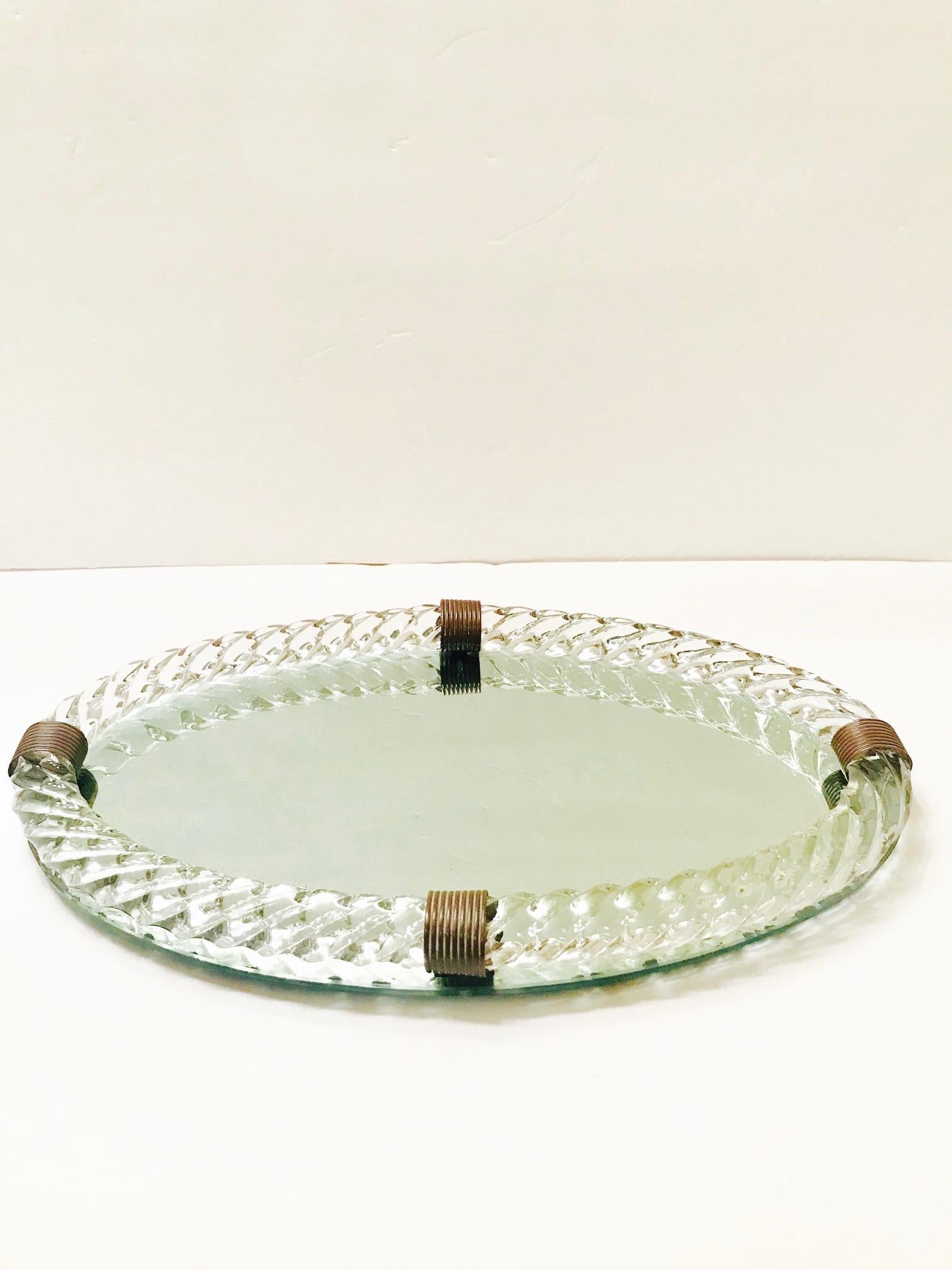 Exquisite Art Deco era mirrored tray with large hand blown Murano glass gallery in the form of twisted rope. The tray has an elegant oval form and features four bronzed metal fittings.