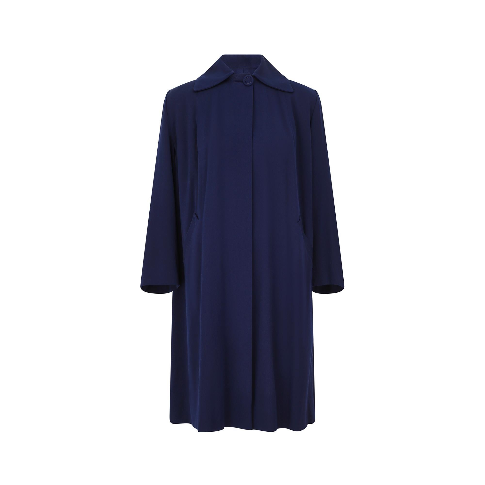 Popularised in the 1940s, the swing or swagger coat’s silhouette was generously cut and its playful, flared look made it a hit with the era’s most glamorous movers and shakers. This coat, which is between royal blue and navy in colour has two labels