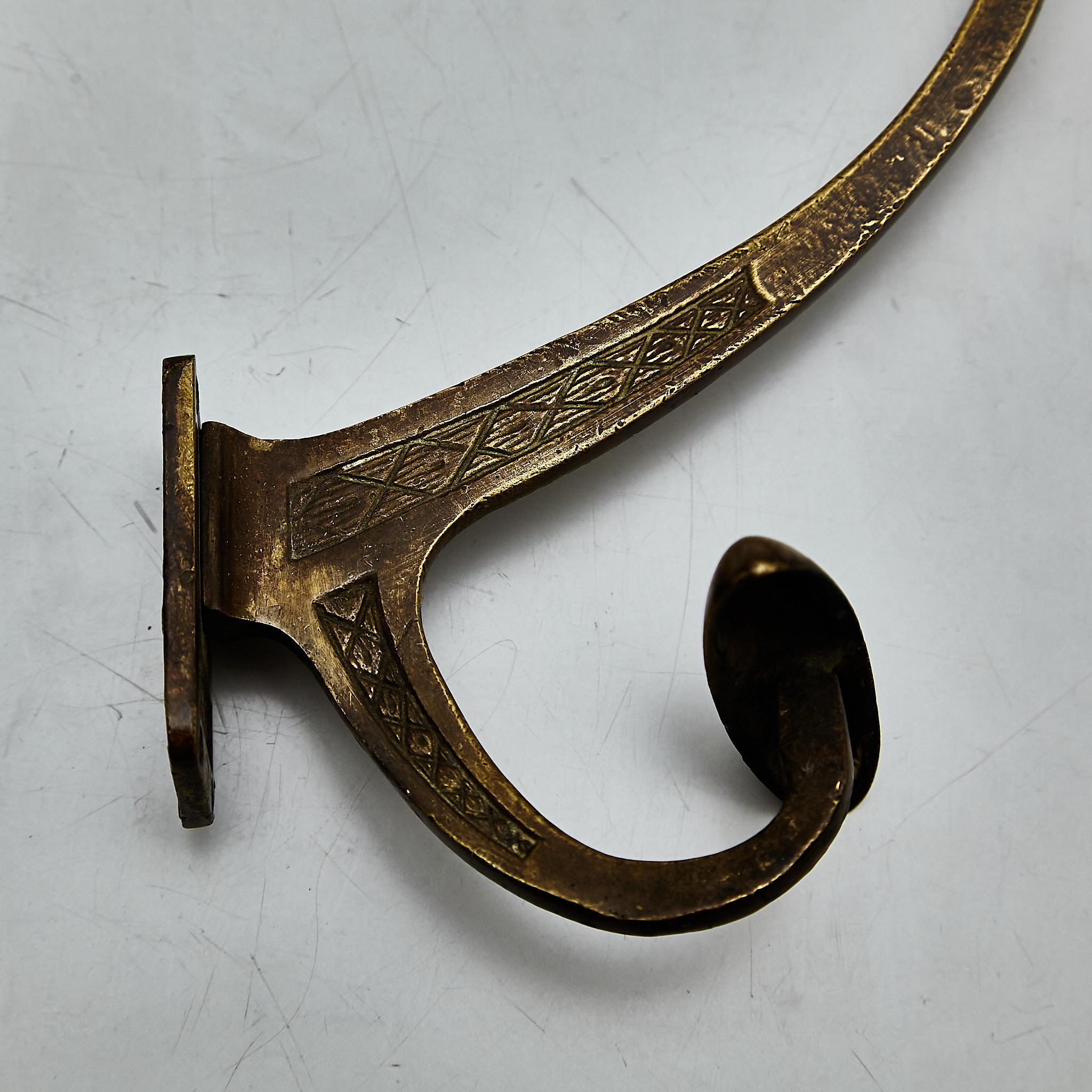 Elevate your wardrobe and decor with this exquisite pair of modernist metal coat hangers, hailing from the 1940s. These timeless pieces have aged gracefully, showcasing a beautiful patina that adds character and charm to their modernist