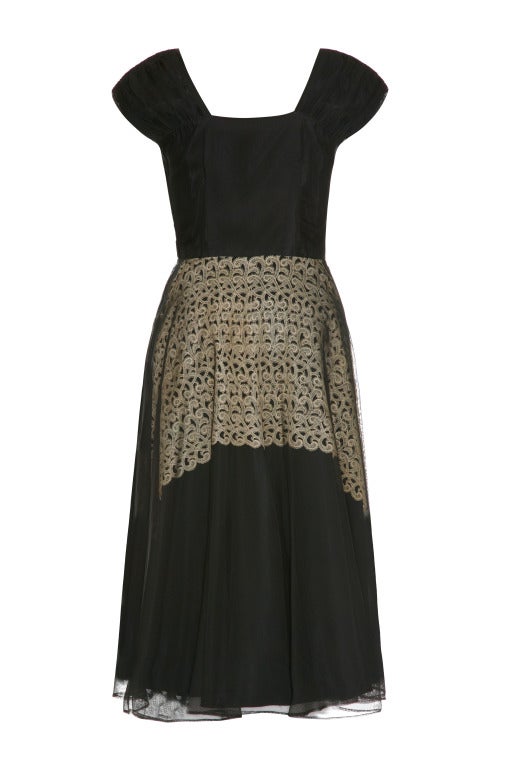 This beautiful vintage 1940s black organza dress features a unique guipure lace under layer in soft cream which is visible beneath the sheer fabric of the skirt, a pretty sweetheart detail on the neckline and wide set, ruched shoulder straps. The
