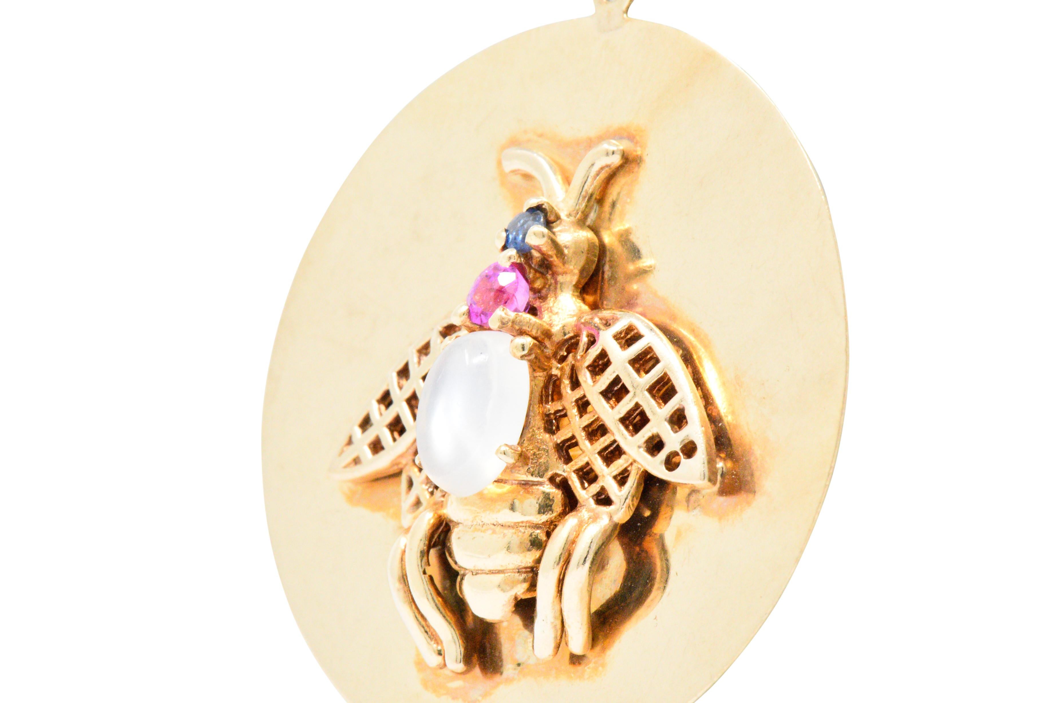 Designed as a polished gold disc with an applied a gem-set bug, with an oval cabochon moonstone and round cut pink sapphire body and round cut sapphire head

Delightful gold detail, polished fluted gold body and lattice gold wings

This large charm