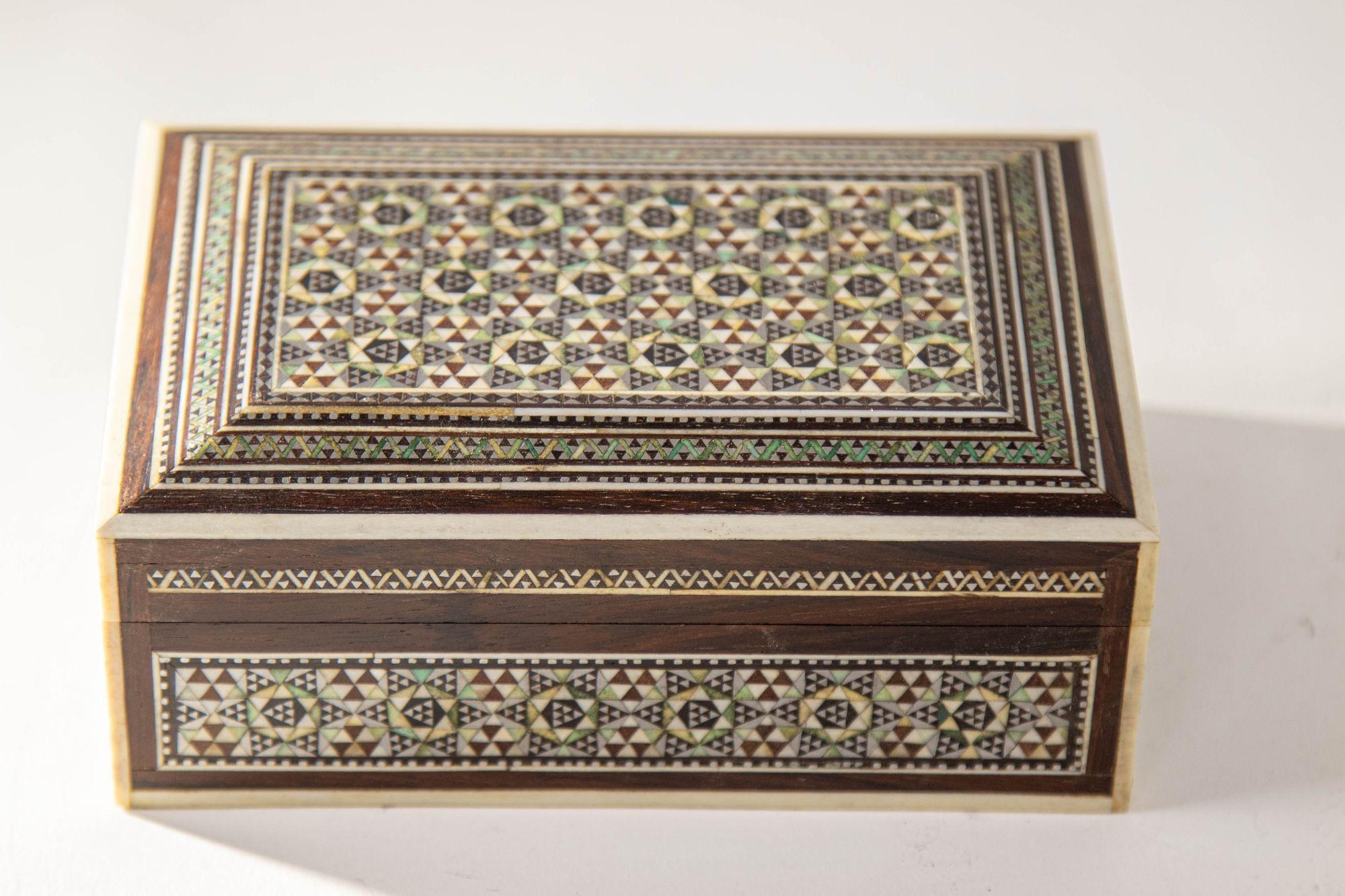 Vintage 1940s Mosaik Perlmutt Intarsien dekorative Nahost islamischen Box.
Mosaik Luxus dekorative Nahost islamischen Vanity Box.
Asiatische Mosaikholzkiste aus dem Nahen Osten mit Intarsien aus Knochen und Perlmutt, um 1940
Exquisite handgefertigte