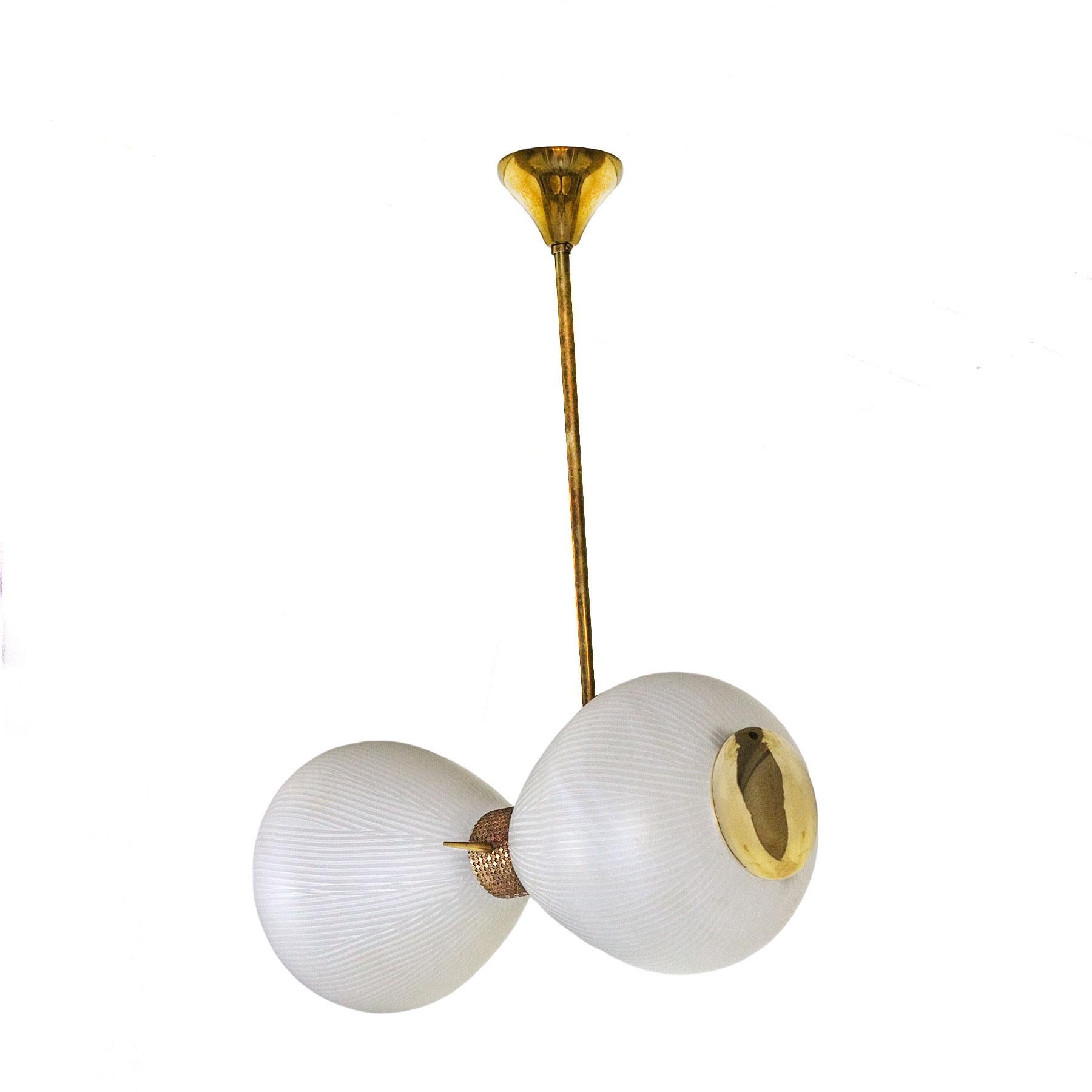 Ravishing Murano two grooved cast glass globes pendant, polished brass decentered suspension shaft. Polished golden brass ring with squares and flowers patterns. Two brass hatches giving access to bulbs lights.
Maker: Venini Co
Murano, Italy,