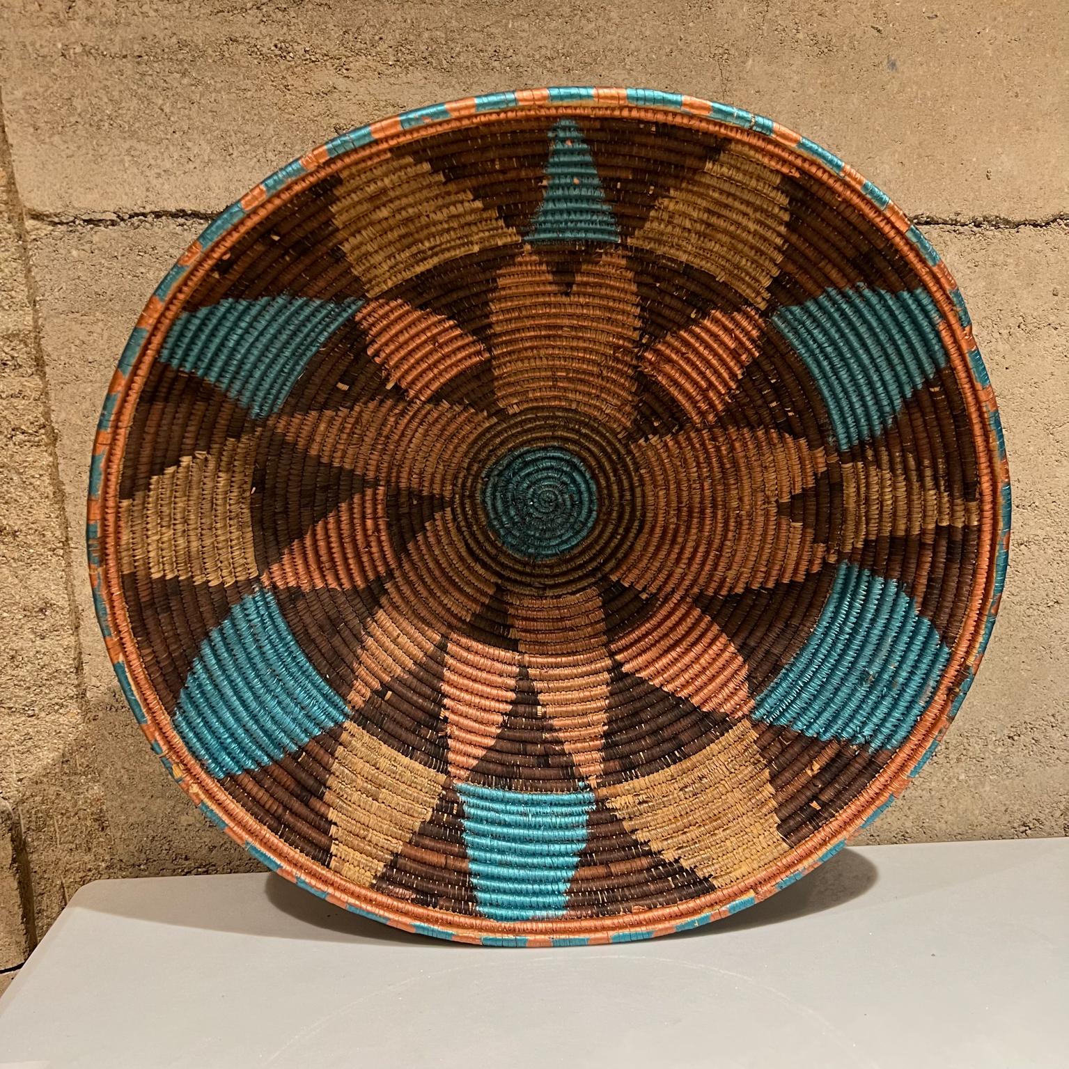 Indian woven basket handmade in rich vibrant color.
Measures: 21 diameter x 7 tall.
Preowned original vintage condition.
Refer to images.

