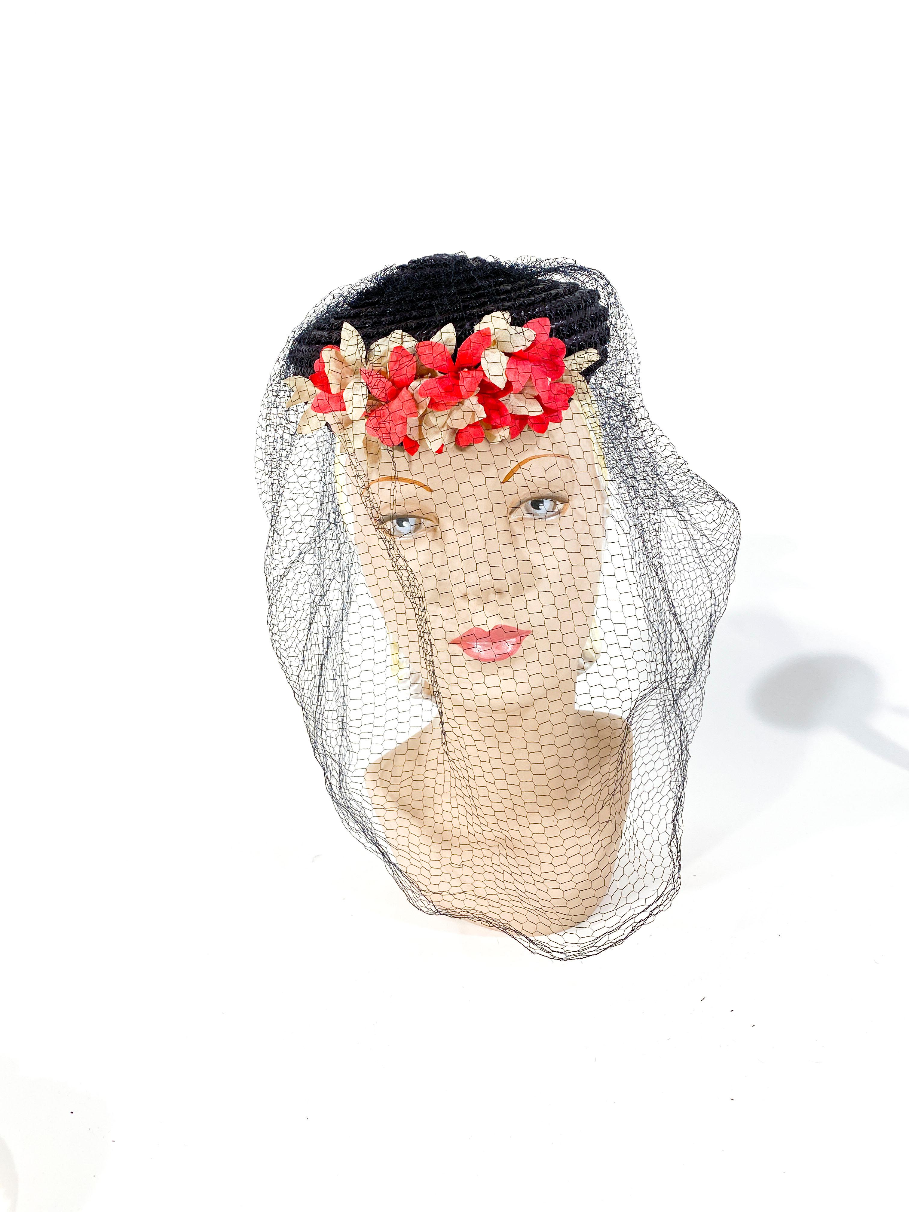 1940s Navy-blue straw perch hat with coral and off-white stiffened linen flowers, and enlarged gorsgrain bow and a full-faced silk veil.