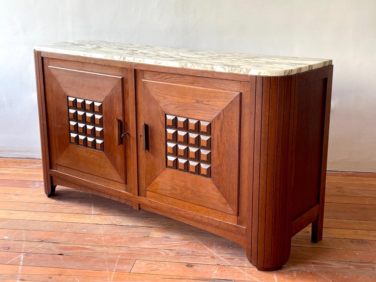 Stunning 1940's oak cabinet with curved lines and marble top. 
Carved ornate doors with open shelving. 
Beautiful shape with curved ends with vertical slat detailing. 
