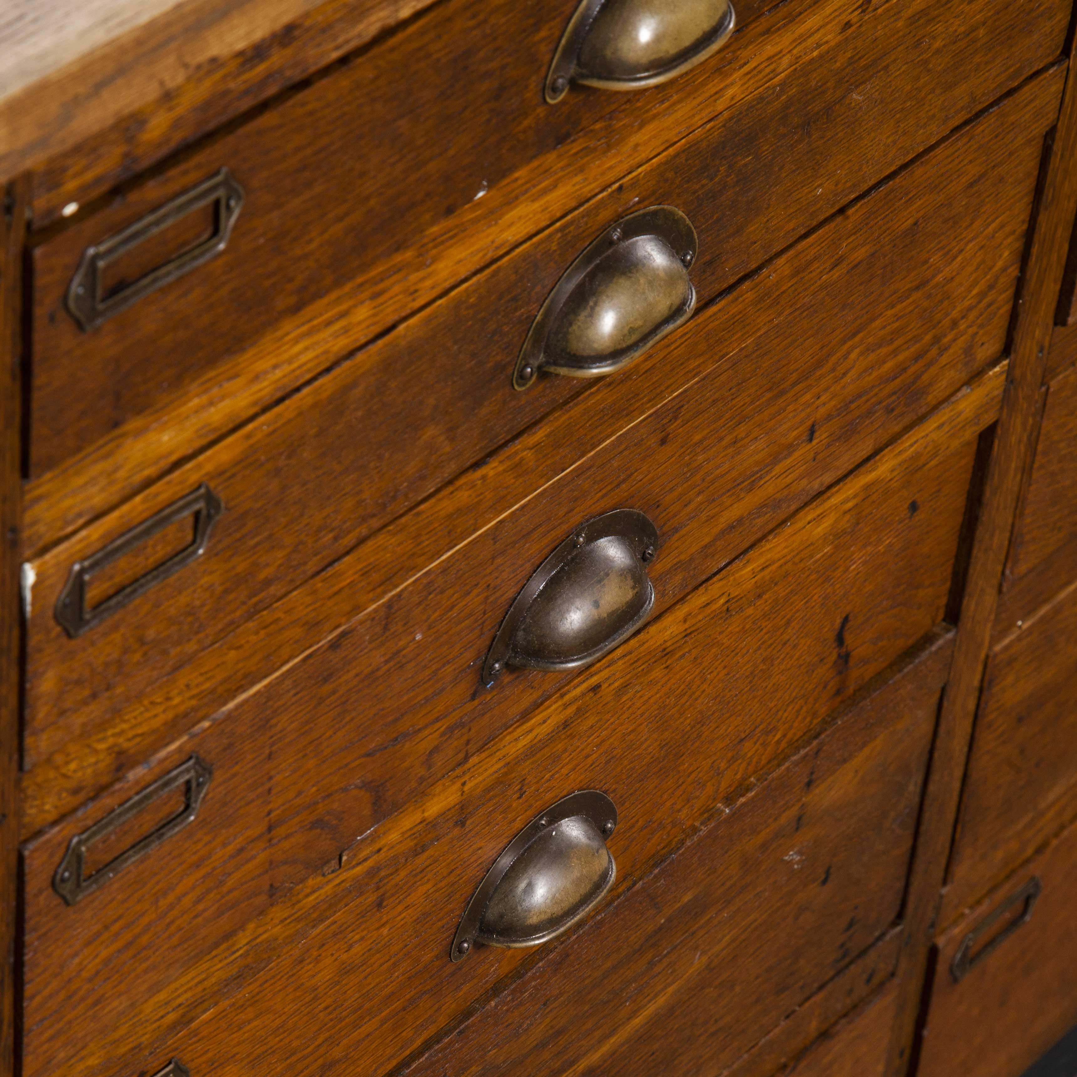 1940s oak low multidrawer apothecary chest of drawers – eighteen drawers. A handsome heavy weight and beautifully made low chest of drawers which was sourced from an apothecary in southern Germany. The carcass is oak throughout in a rich warm