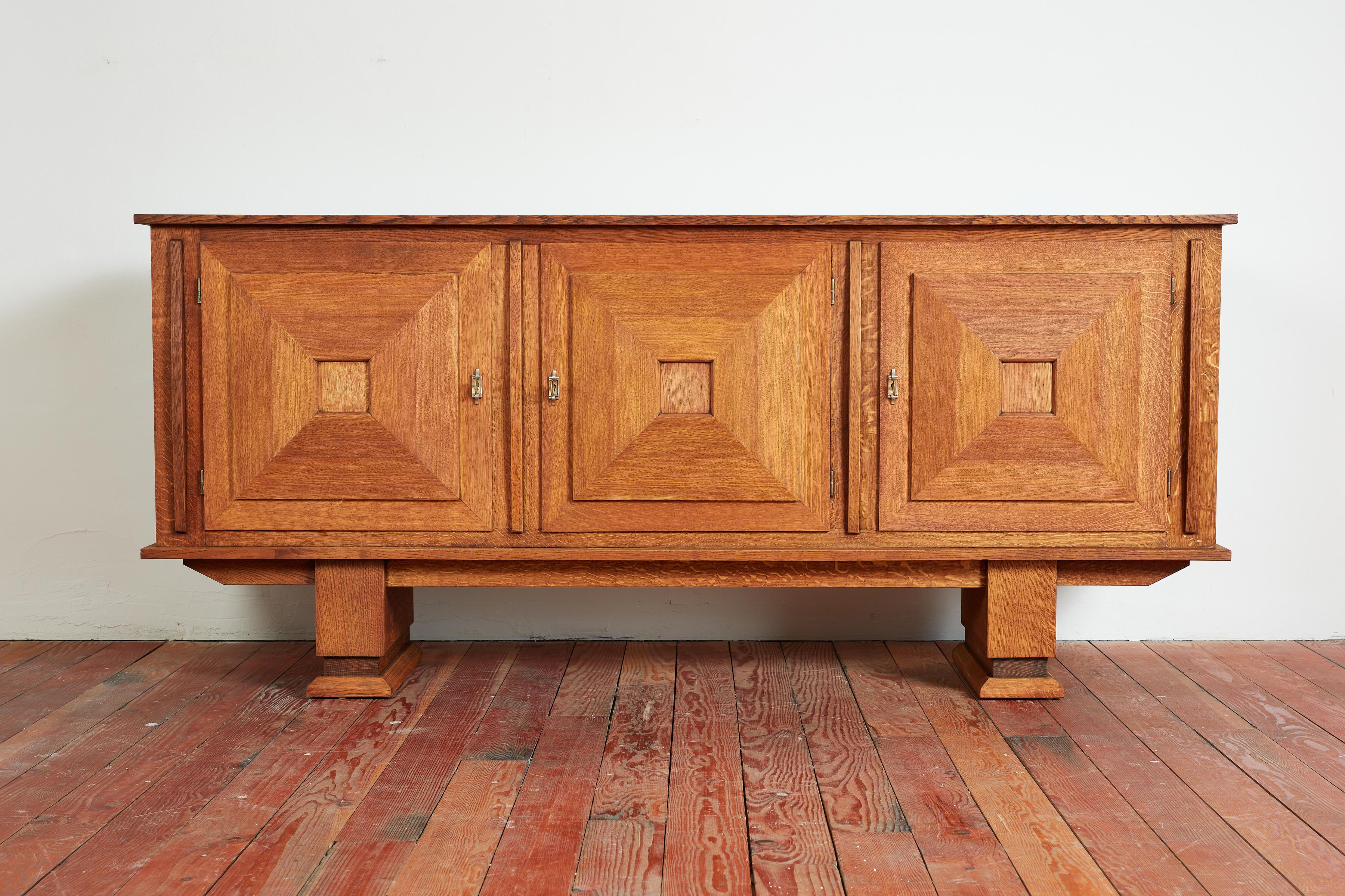 Simple oak sideboard with clean linear lines - France, 1940s
3 individual doors to open shelving with inlay detail and small drawers on both sides. 
Wonderful patina and checkerboard patterned top.
