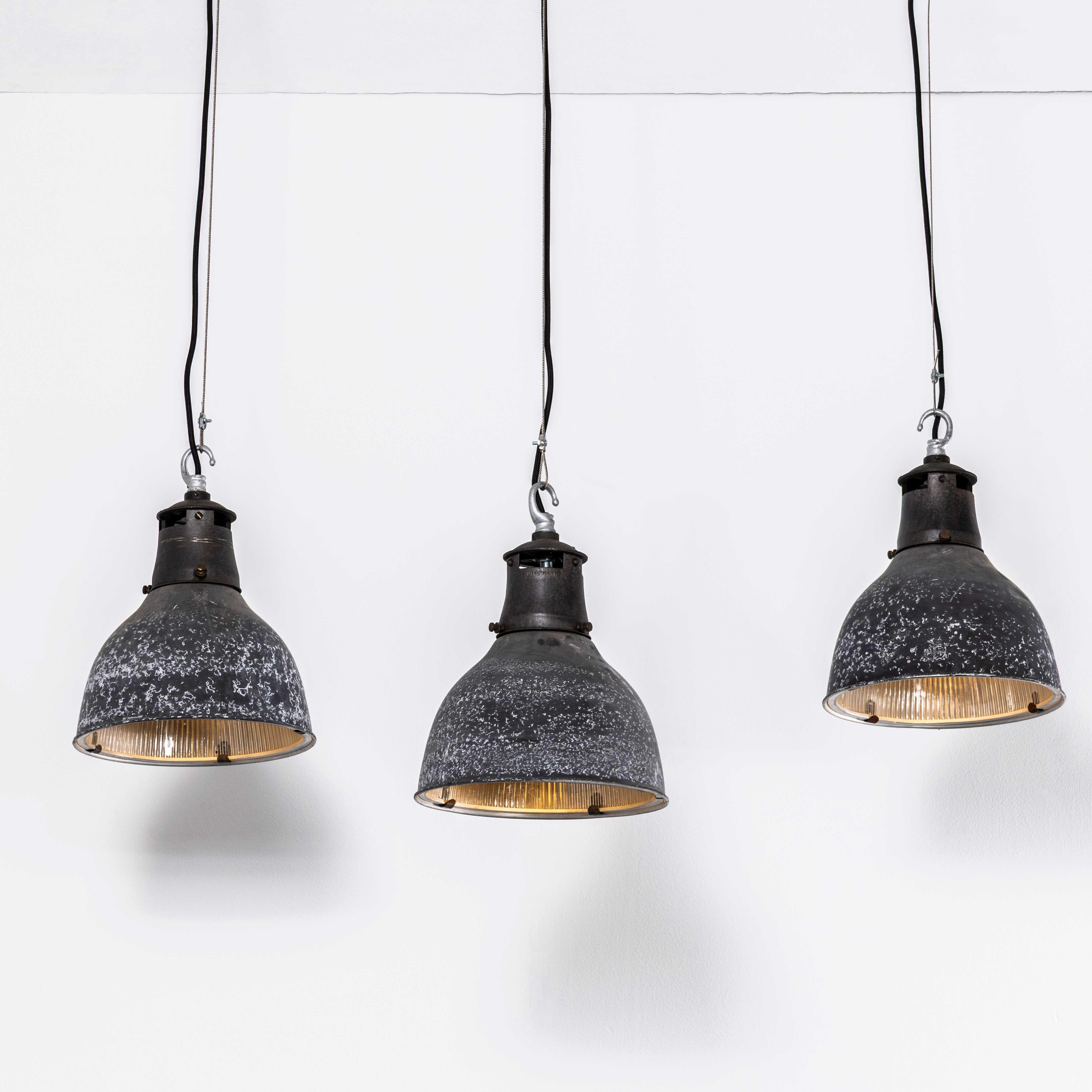 Lampes pendantes prismatiques mouchetées en Holophane d'origine des années 1940. 
Fondée en France à la fin du XIXe siècle, Holophane est célèbre pour avoir inventé et perfectionné des réflecteurs en verre borosilicaté, souvent ornés de motifs