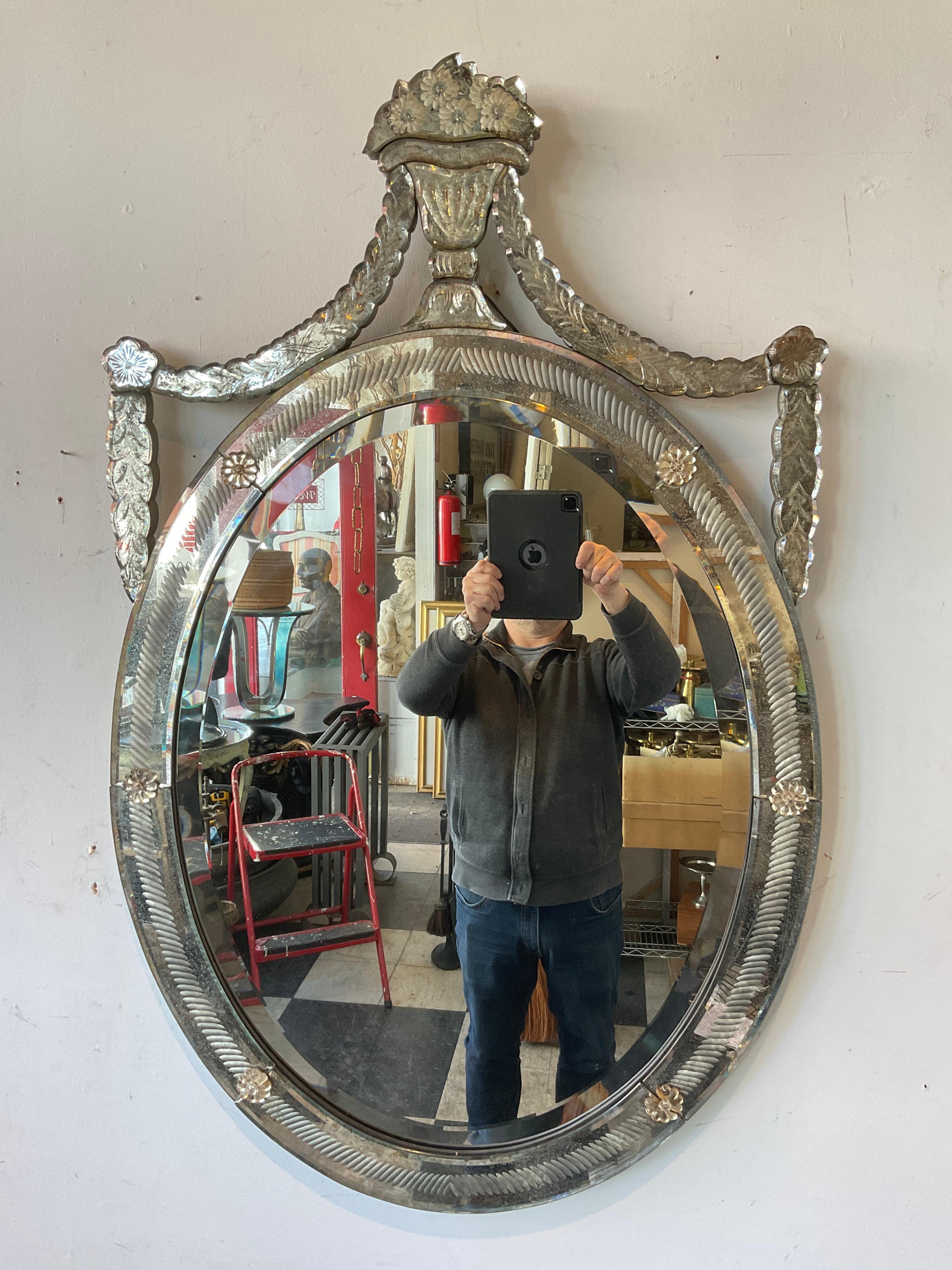 1940s oval venetian mirror. Basket of flowers and garland on top. Mirror has great dark age spots on it. I have never seen this form before .