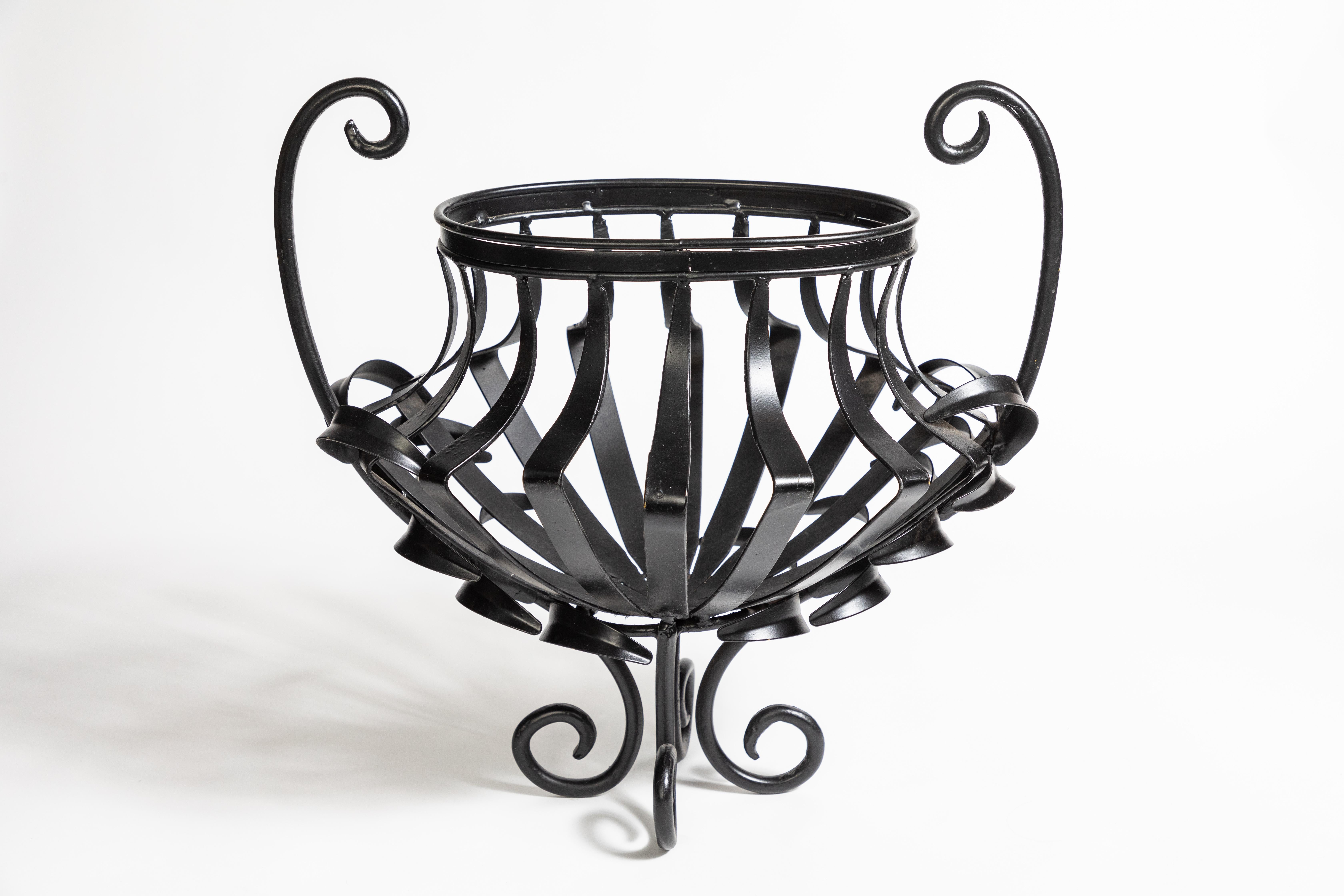 1940s oval wrought iron urn strap planter with scroll feet and handles

Newly refinished with black lacquer.