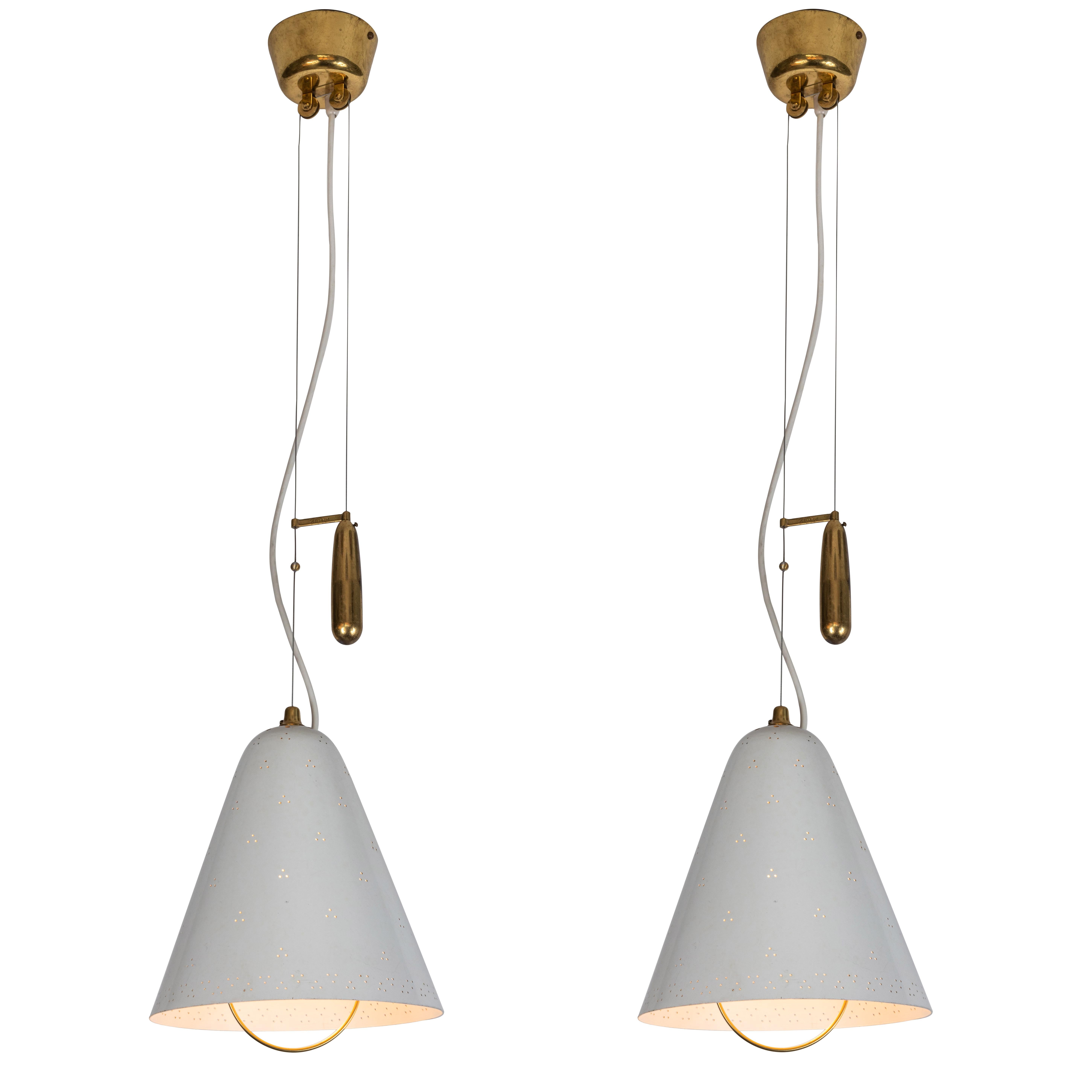 1940s Paavo Tynell 'A1942' counterweight pendants for Idman Oy. This rare and exceptional pendant is executed in white painted perforated metal and brass, and can be raised and lowered using its ingenious counterweight and pulley system.