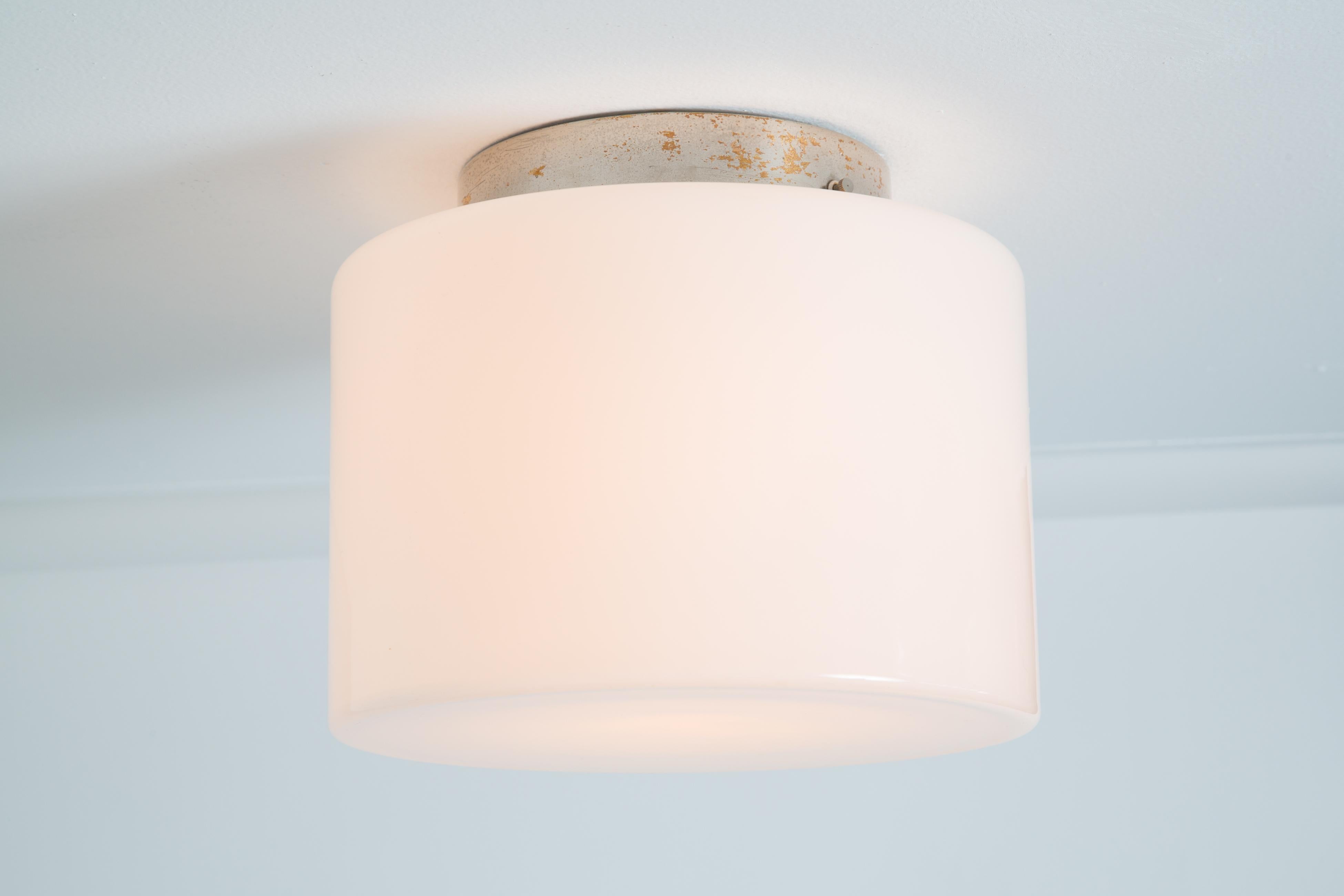 1940s Paavo Tynell Model #2024 glass & metal flush mount for Taito Oy. This rare and exceptional flush mount is executed in white opaline glass and metal. Manufactured by Taito in the late 1940s, this is a fine unsigned example of a Tynell's iconic