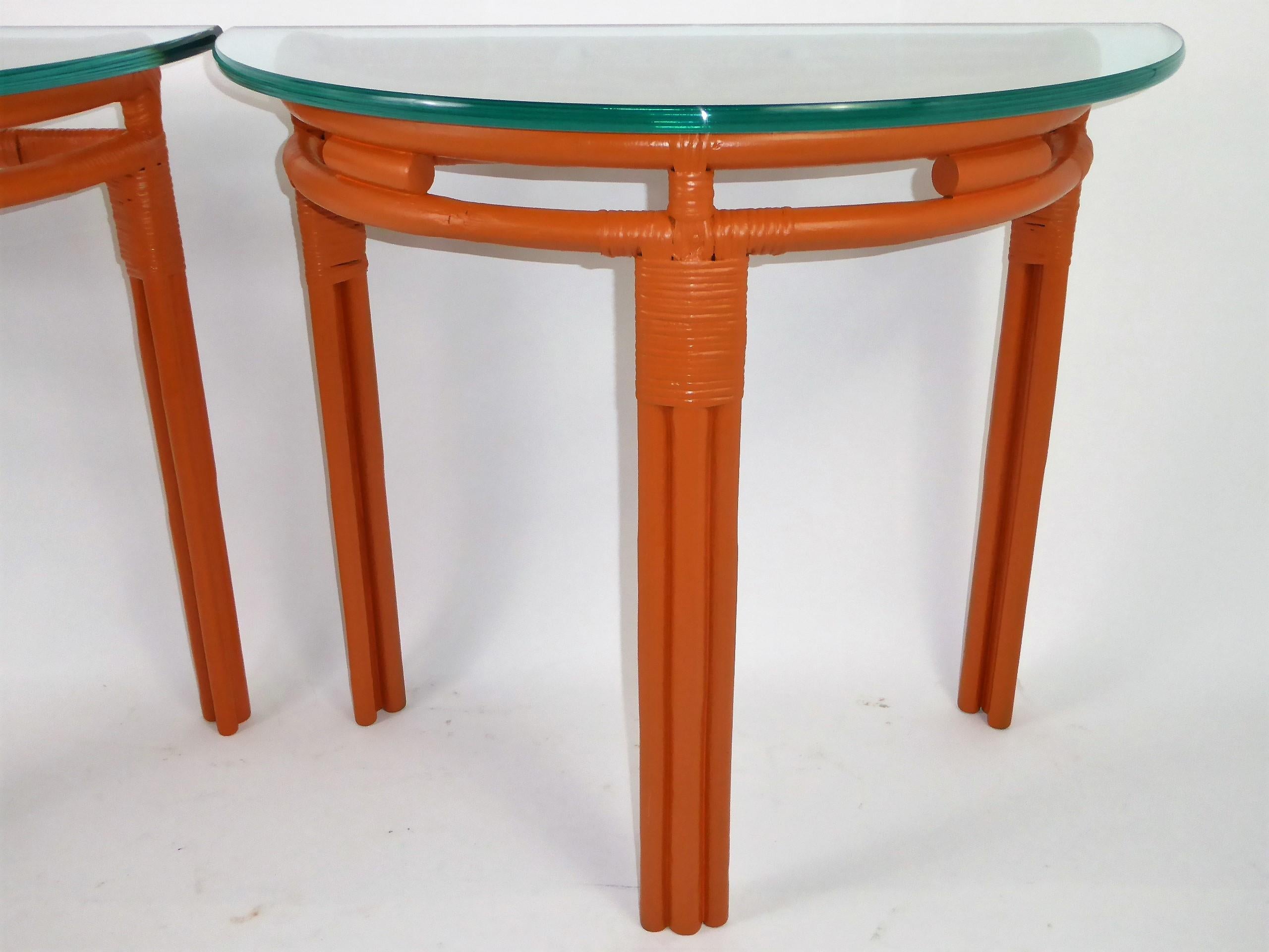 Pair of 1940s rattan demilune consoles with 3/4 inch thick glass tops. Painted in a Hermes Orange, the unique rattan design seen from the top features a stylized stirrup. New glass.
Ideal for the foyer opposite each other or anywhere matching