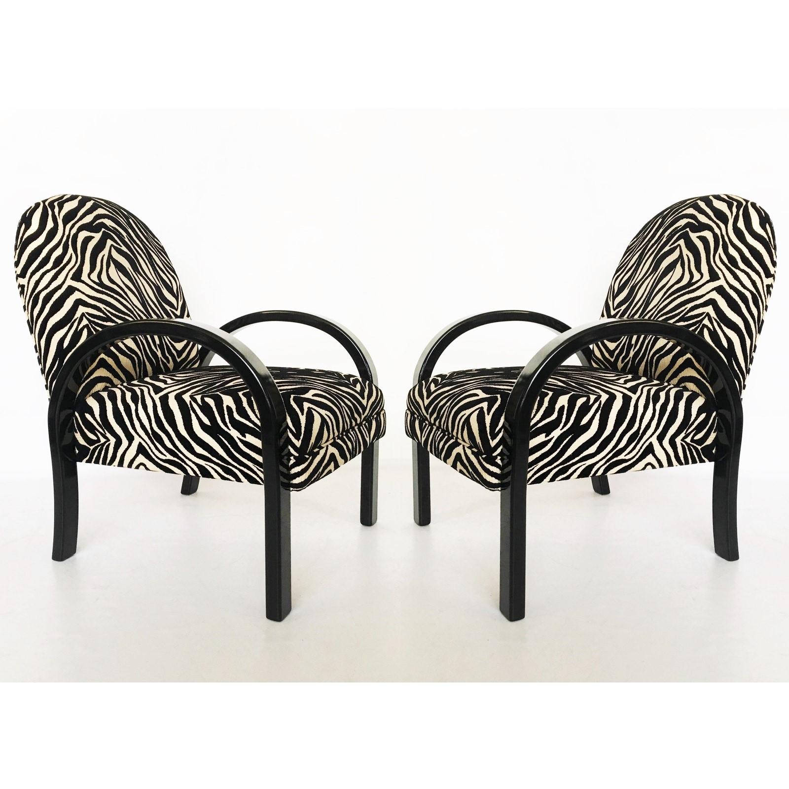 Beautifully figured pair of Art Deco easy chairs in the style of Jindrich Halabala. The construction of the frame and the seemingly floating upholstered seats give the chairs a sculptural presence. Features a black lacquered wood frames, richly