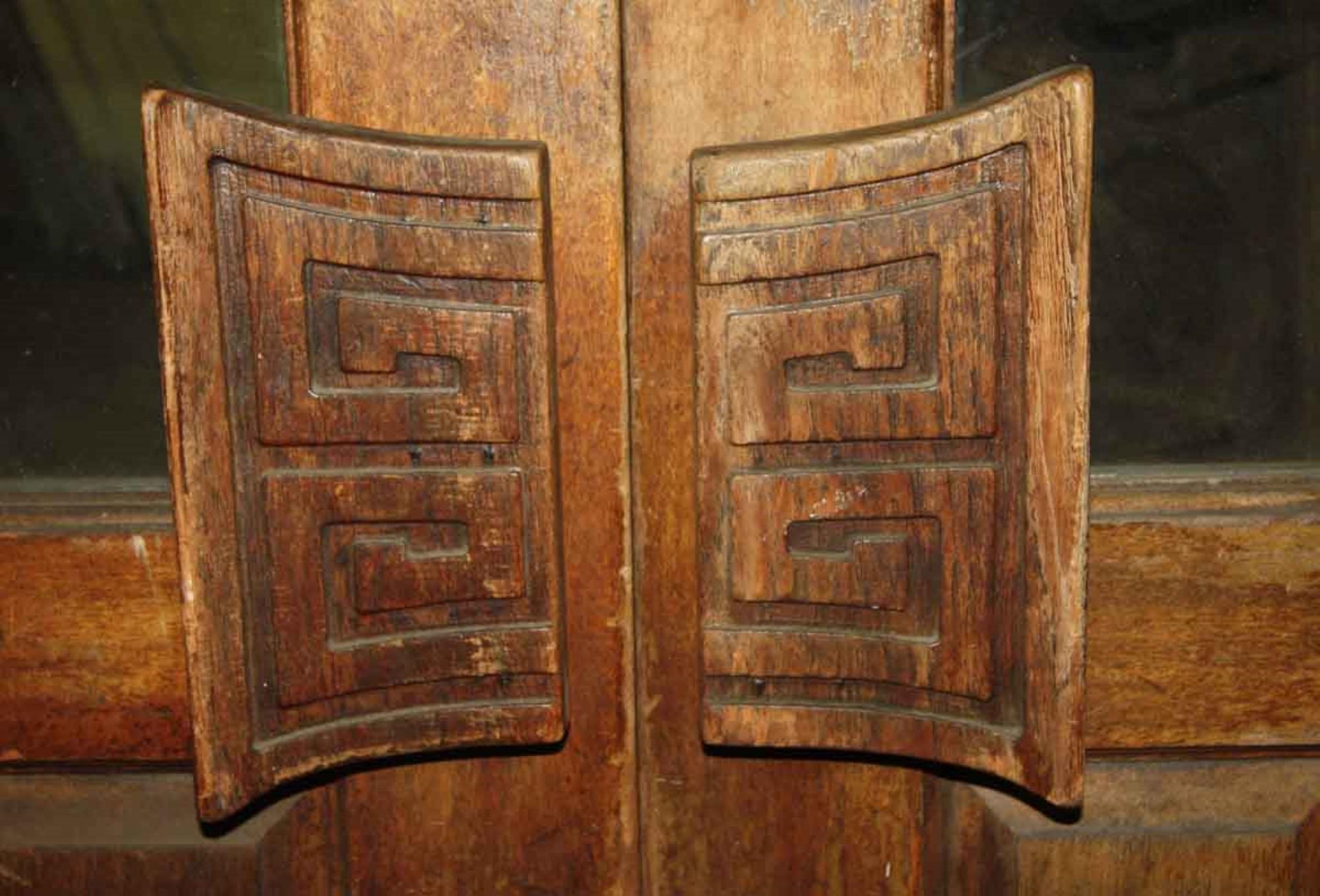 1940s tall dark tone 8-panel and 2 lite carved wood doors with carved handles as a focus point. Some original hardware is still attached. This can be seen at our 400 Gilligan St location in Scranton. PA.