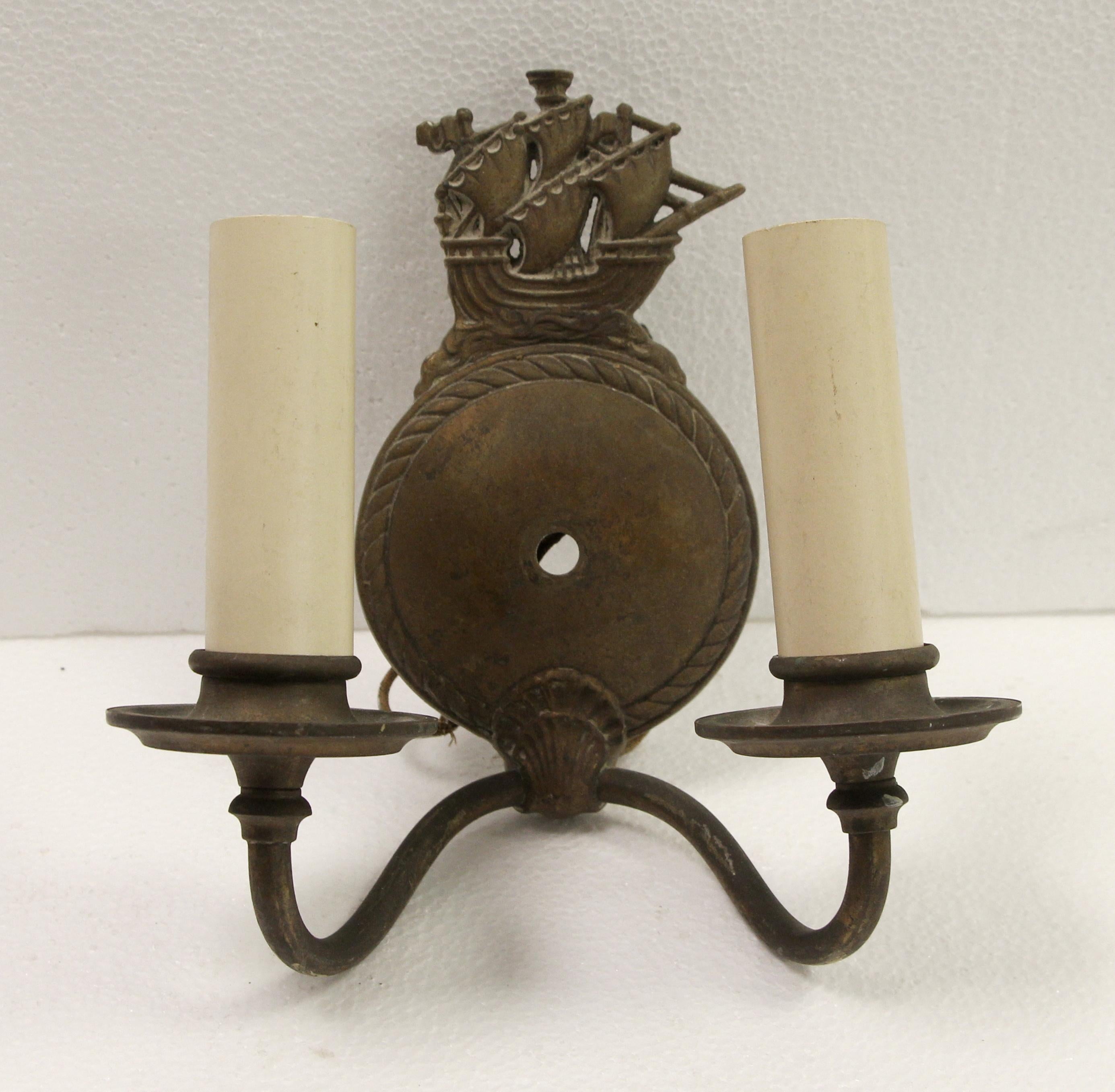 1940s nautical style two arm sconces with a sailing ship galleon motif at the top. Made of bronze in an antique finish. Sold as a pair. These will be cleaned and rewired before shipping. Please note, this item is located in our Scranton, PA location.