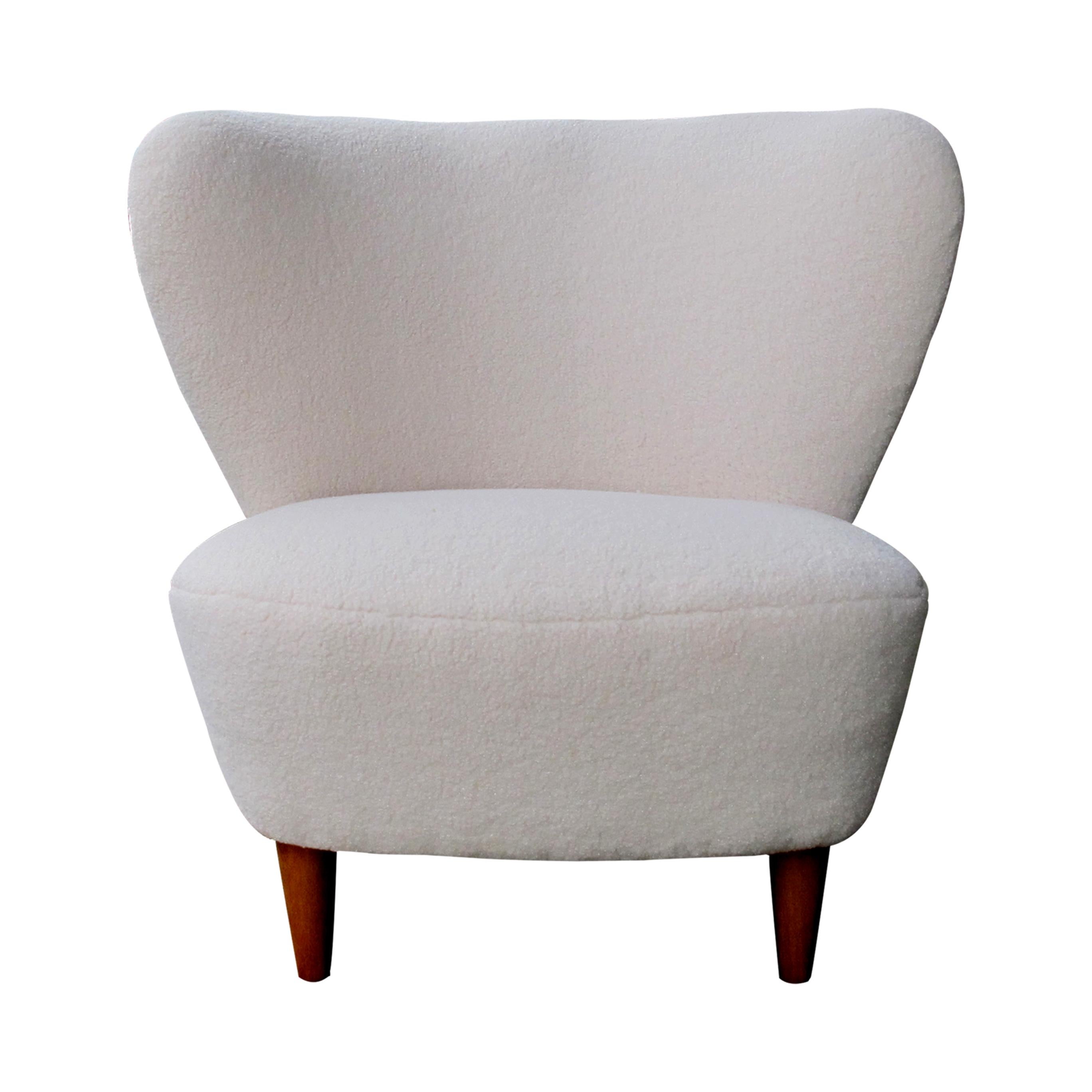 Pair of 1940s Swedish deep-seated armchairs with generous curved backrests designed by Gösta Jonsson. These armchairs/easy chairs are exceptionally well-proportioned and well-padded for extra comfort. The chairs are newly upholstered in light cream