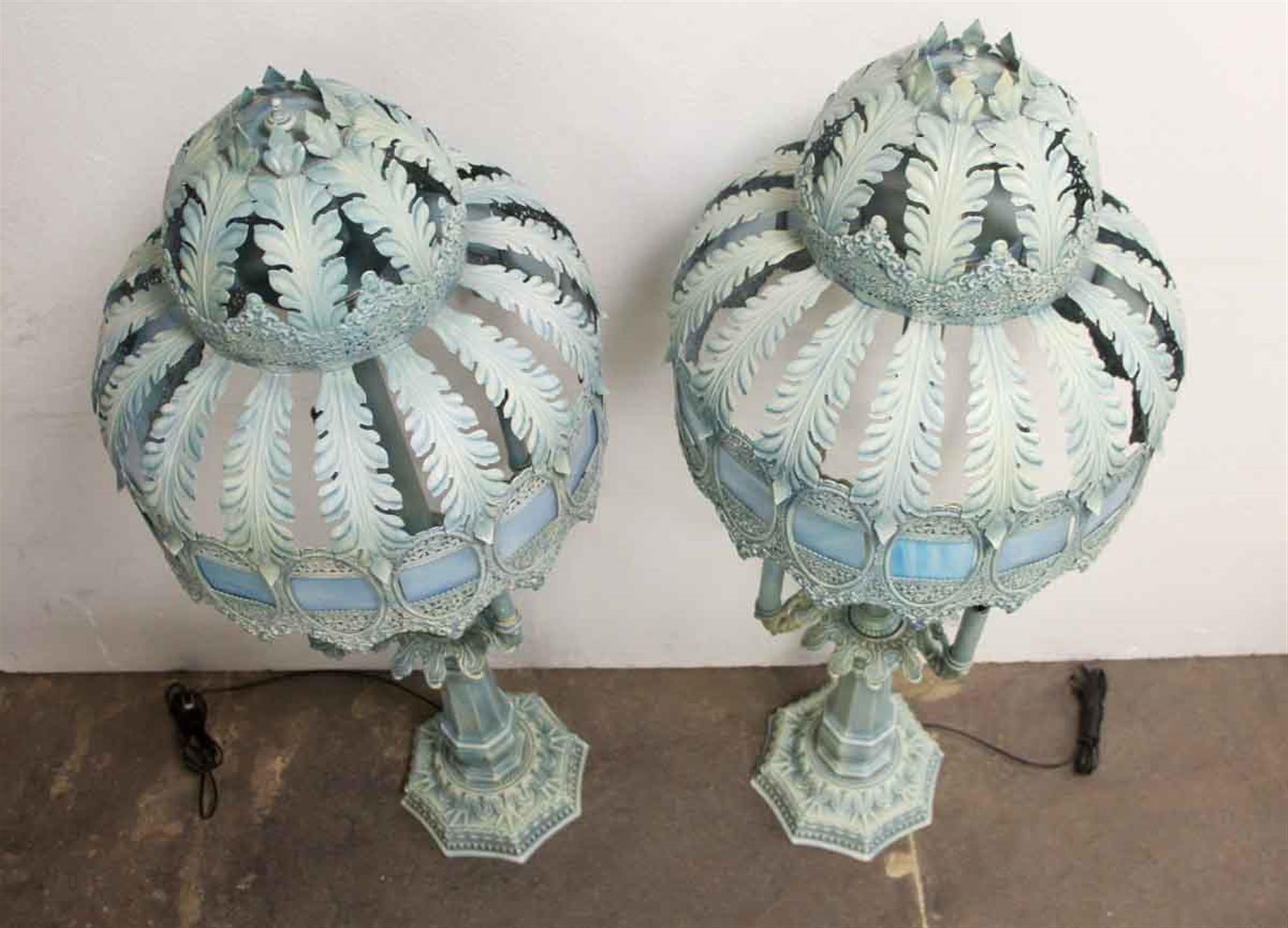 1940s pair of table lamps with blue slag glass along the midsection of each shade. The lamp takes four candelabra bulbs halfway up, and two candelabra bulbs at the top of the lamp, which are under the shade. This can be seen at our 302 Bowery