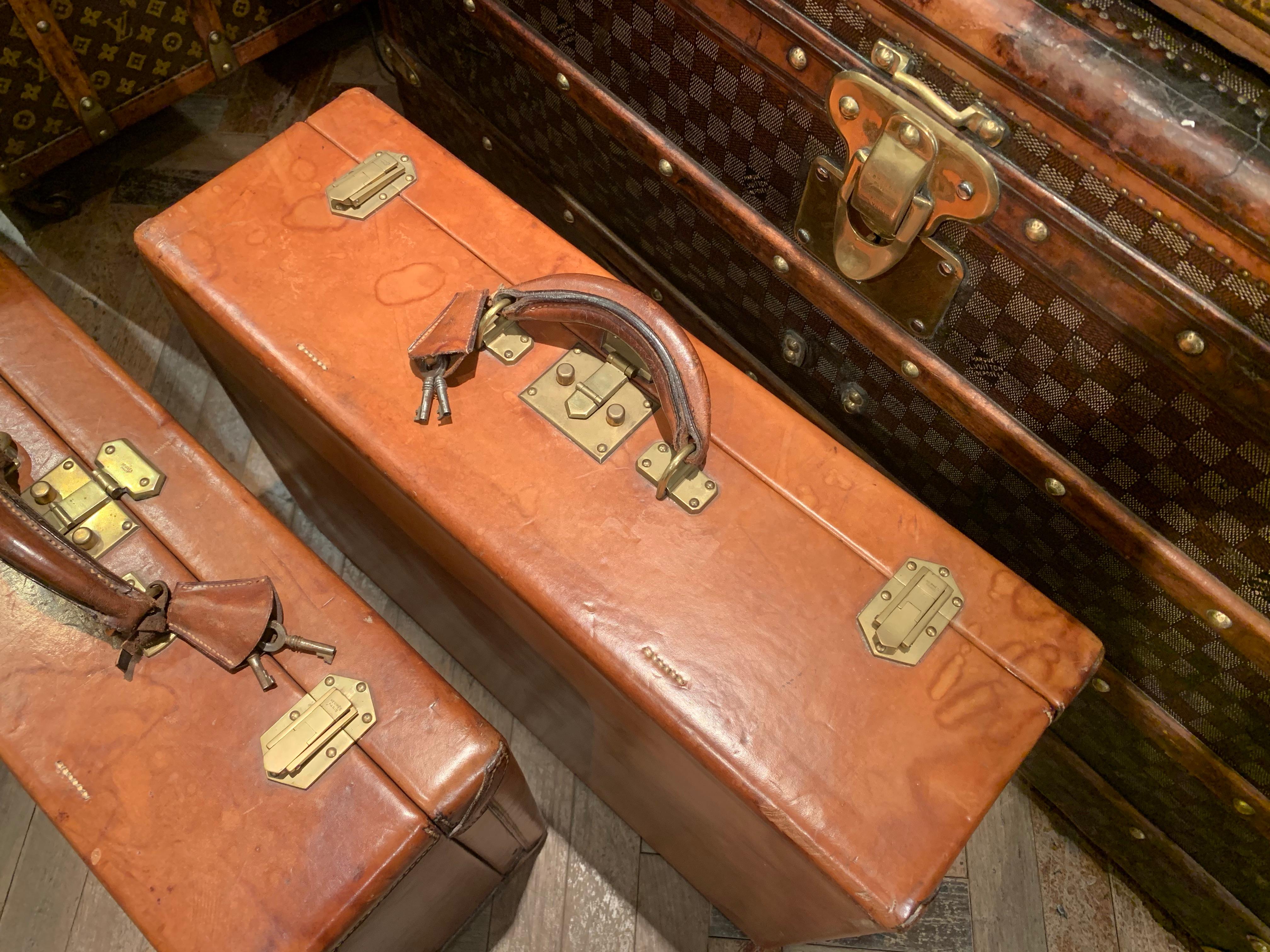 Two very rare Hermès suitcase in natural cow hide covering and brass locks and side latches, made in France, circa 1940s. 
Inside a beige fabric lining
The outside leather has some marks of wear and water stains.

Dimensions:
Small suitcase: 50