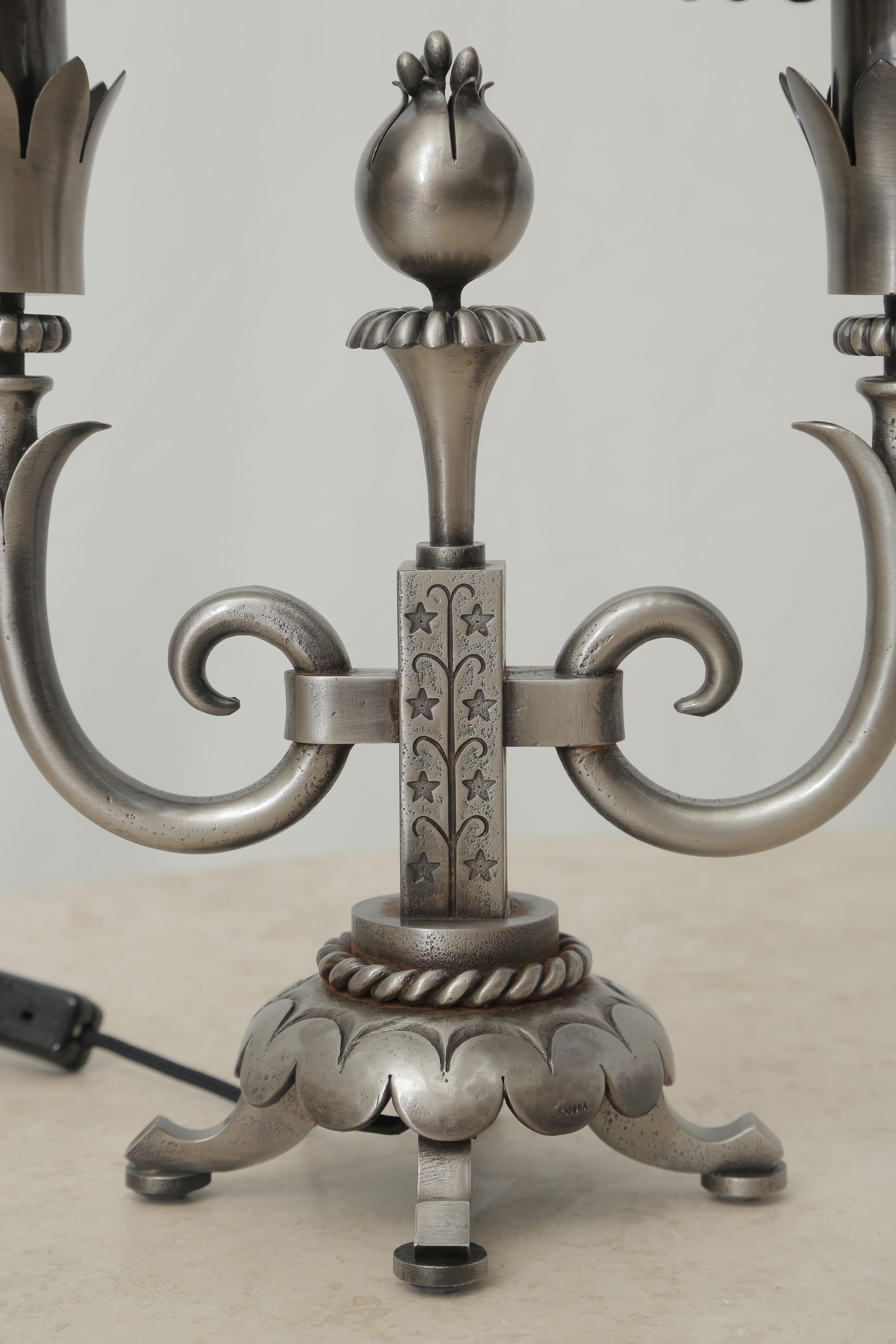 Wrought iron pair of table lamps attributed to Gilbert Poillerat, circa 1940, recently cleaned and polished. Very harmonious sculpture details with the rope around the base of each piece and the pomegranate fruit in the central part of each lamp,