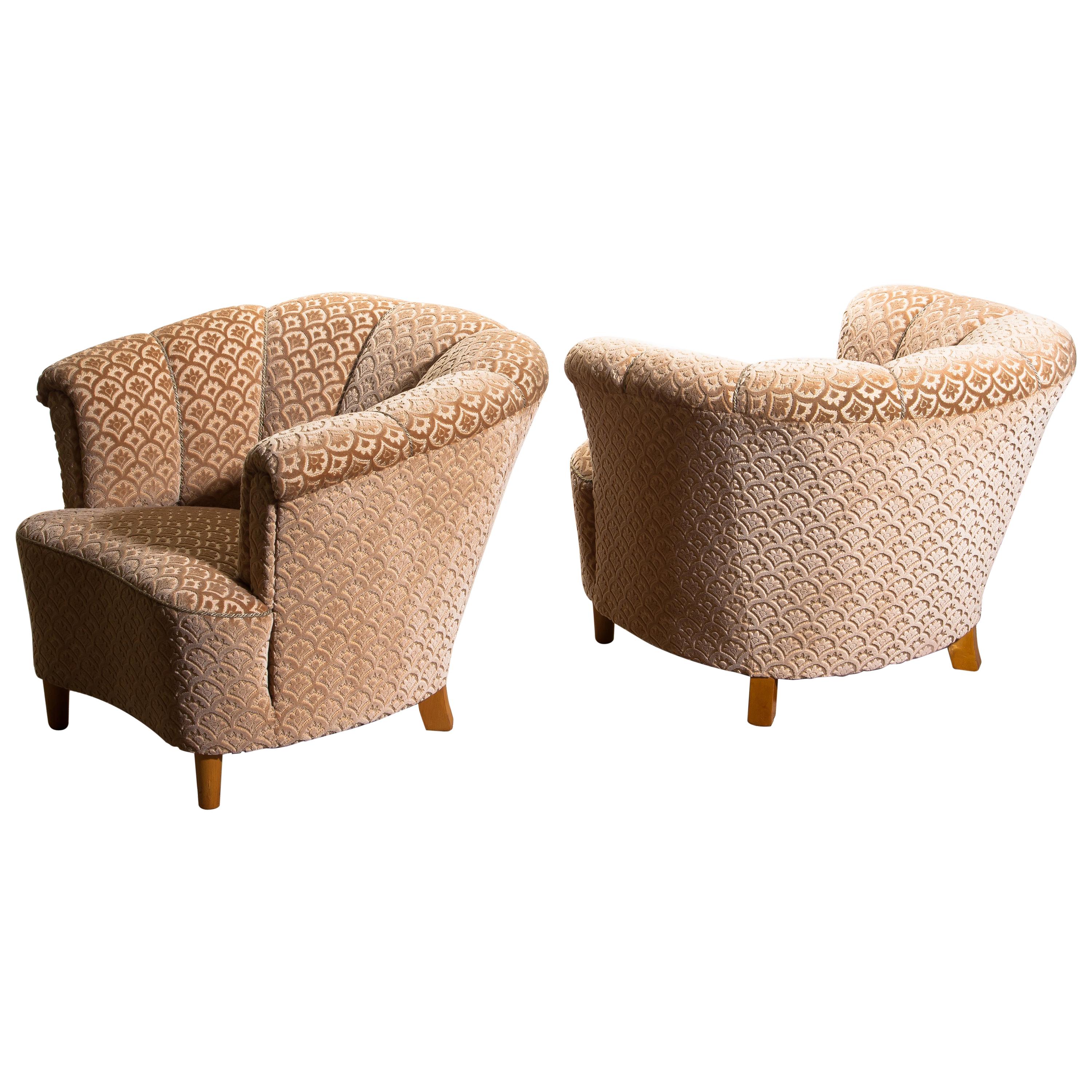 Beautiful set of two comfortable club lounge cocktail chairs from the 1940s.
Both chairs are in original and excellent condition.
The chairs are richly upholstered in flocked velvet and standing on beech legs.
  