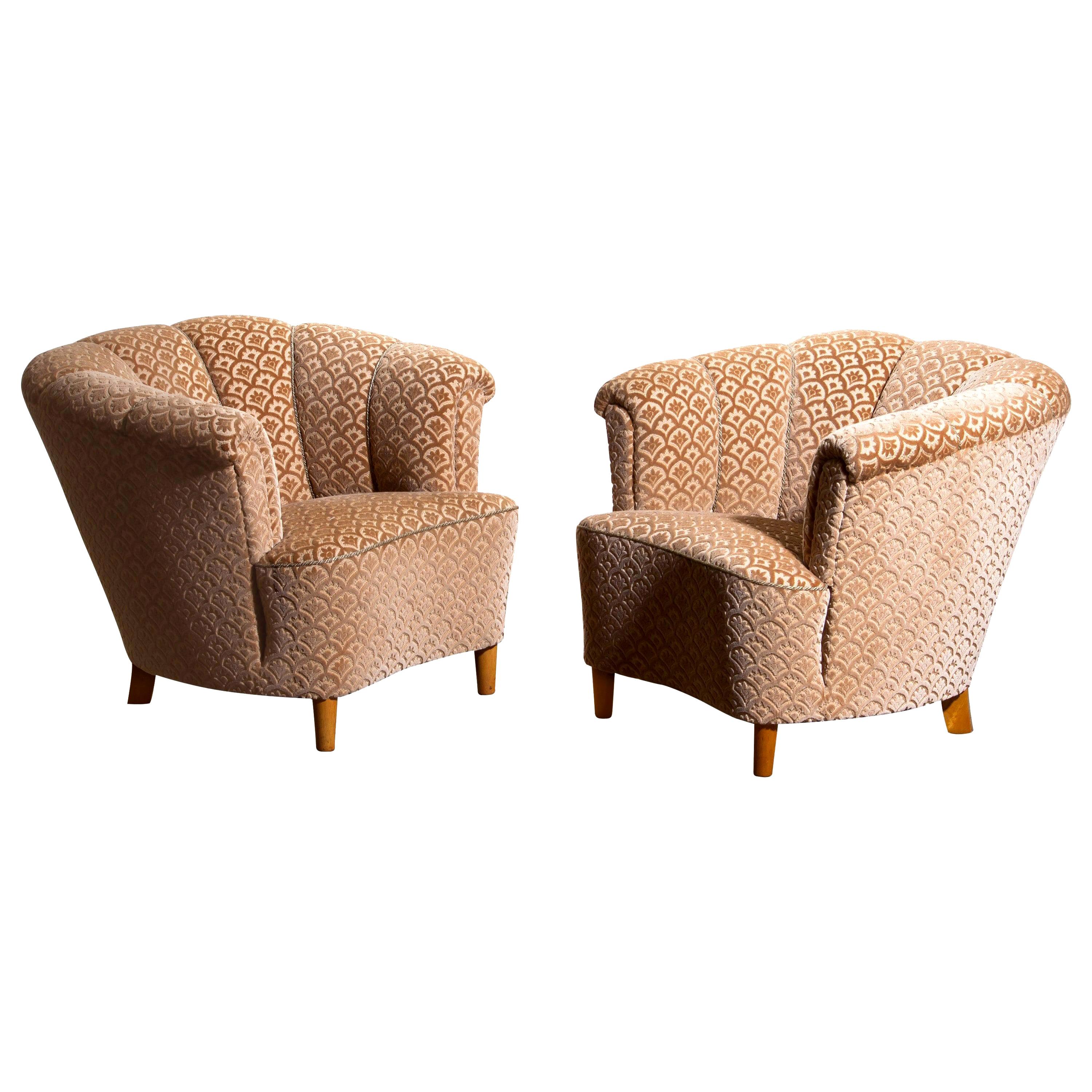 Beautiful set of two comfortable club lounge cocktail chairs from the 1940s.
Both chairs are in original and excellent condition.
The chairs are richly upholstered in flocked velvet and standing on beech legs.
   