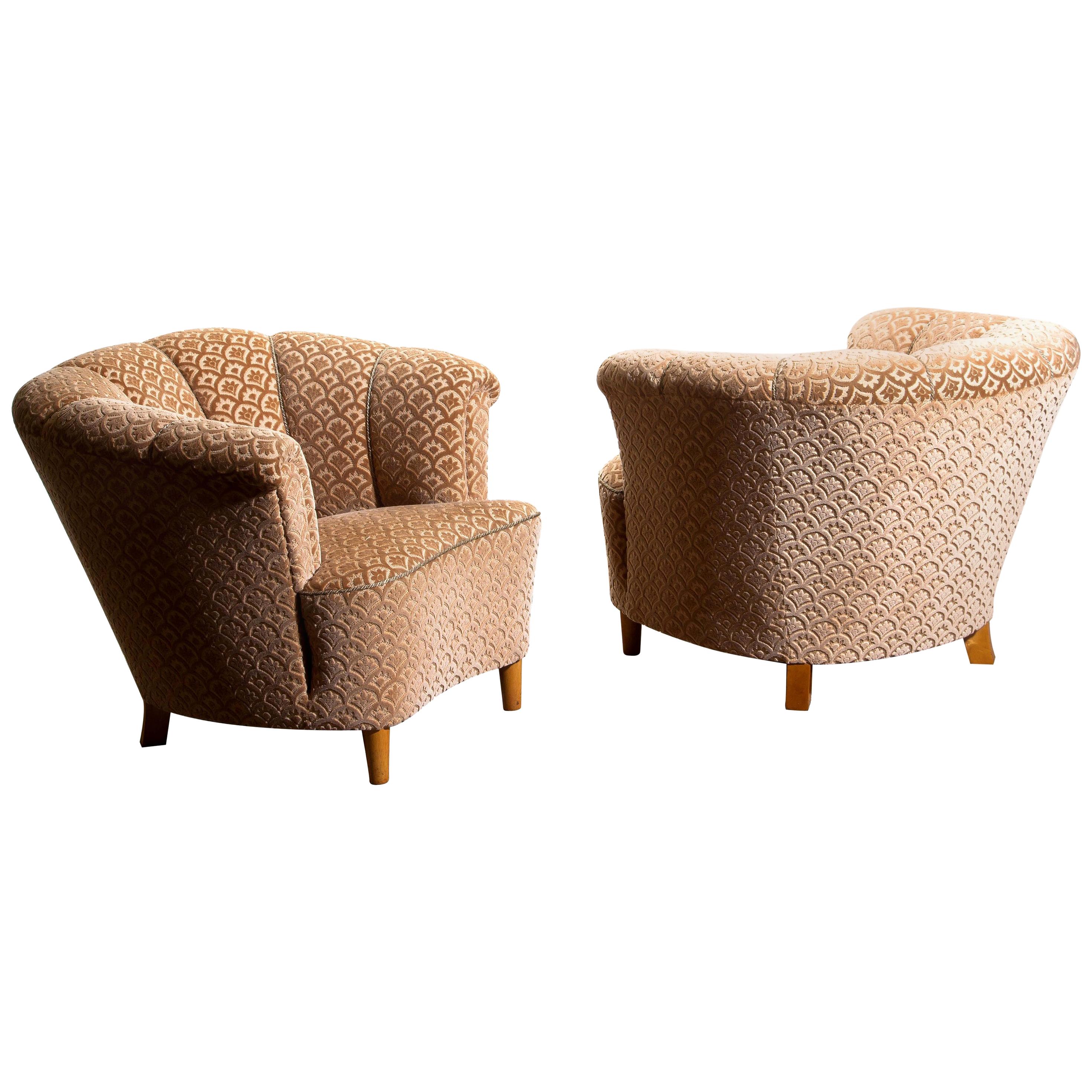 Beautiful set of two comfortable club lounge cocktail chairs from the 1940s.
Both chairs are in original and excellent condition.
The chairs are richly upholstered in flocked velvet and standing on beech legs.
 