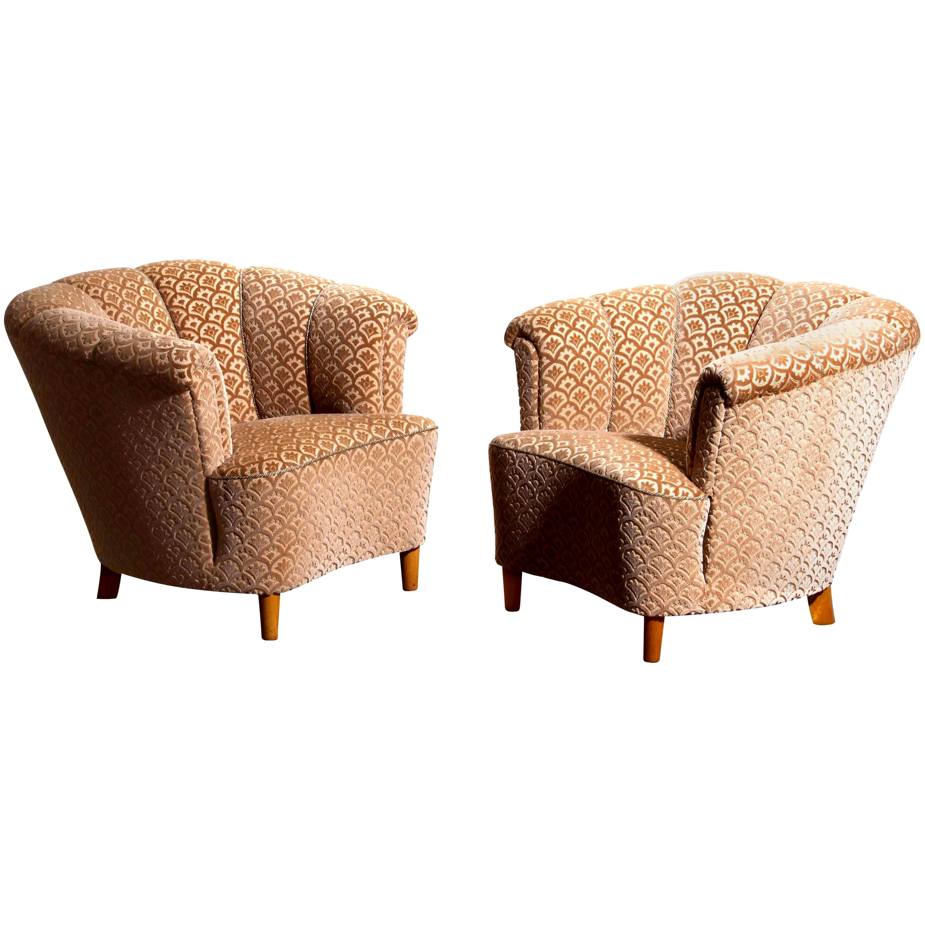 Beautiful set of two comfortable club lounge cocktail chairs from the 1940s.
Both chairs are in original and excellent condition.
The chairs are richly upholstered in flocked velvet and standing on beech legs.
  